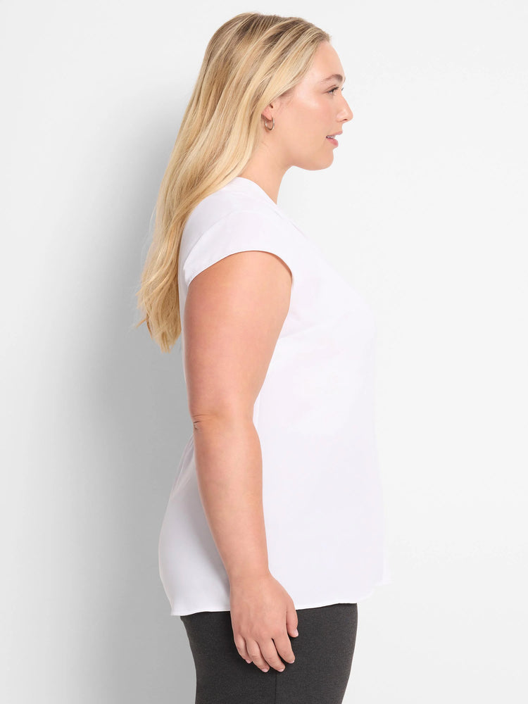 White cap sleeve top with a rounded neckline and relaxed fit, shown on a model in side profile.
