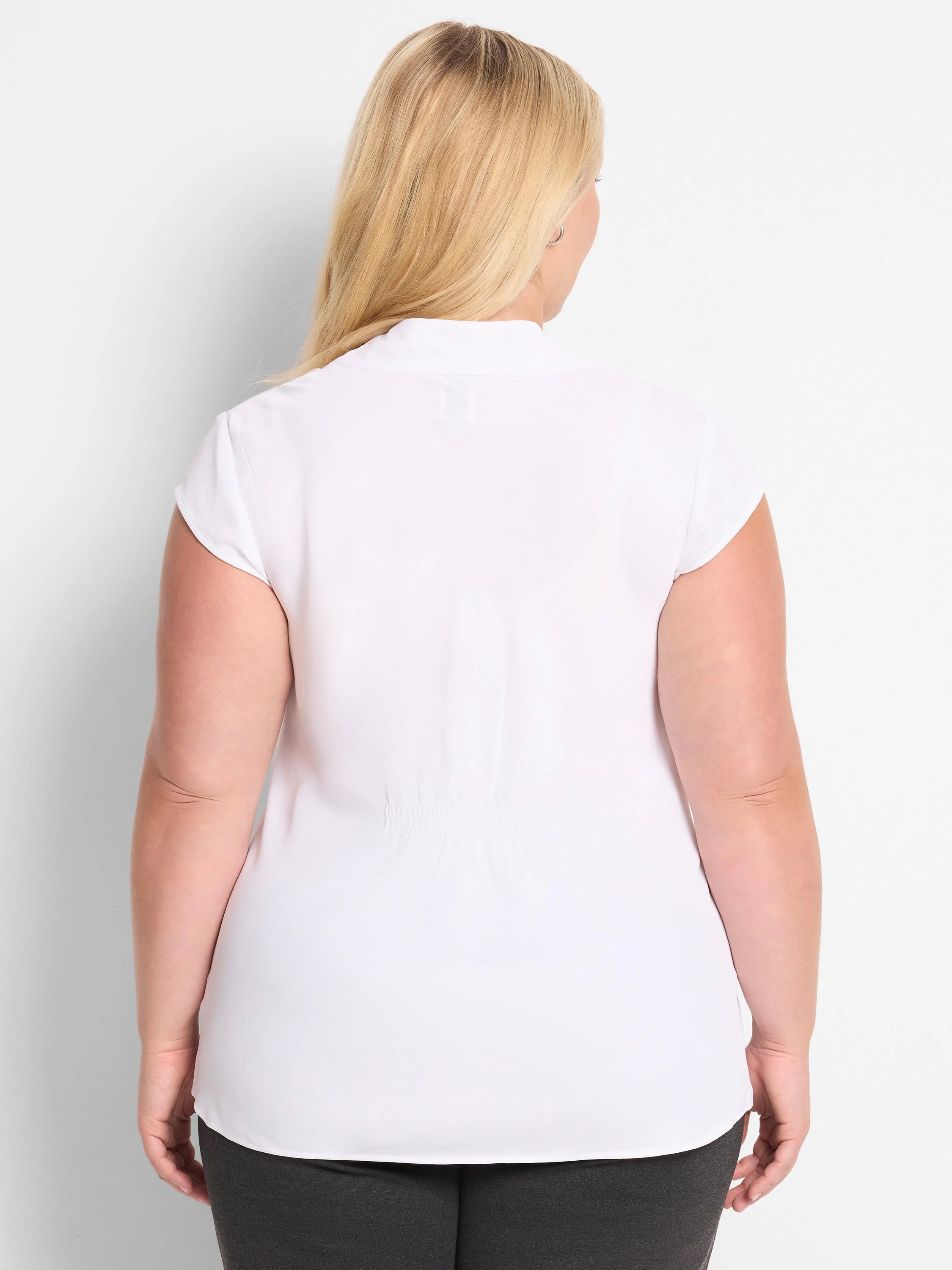 White cap sleeve top, seen from the back. It has a relaxed fit, subtle shirring at the lower back, and a rounded hem.