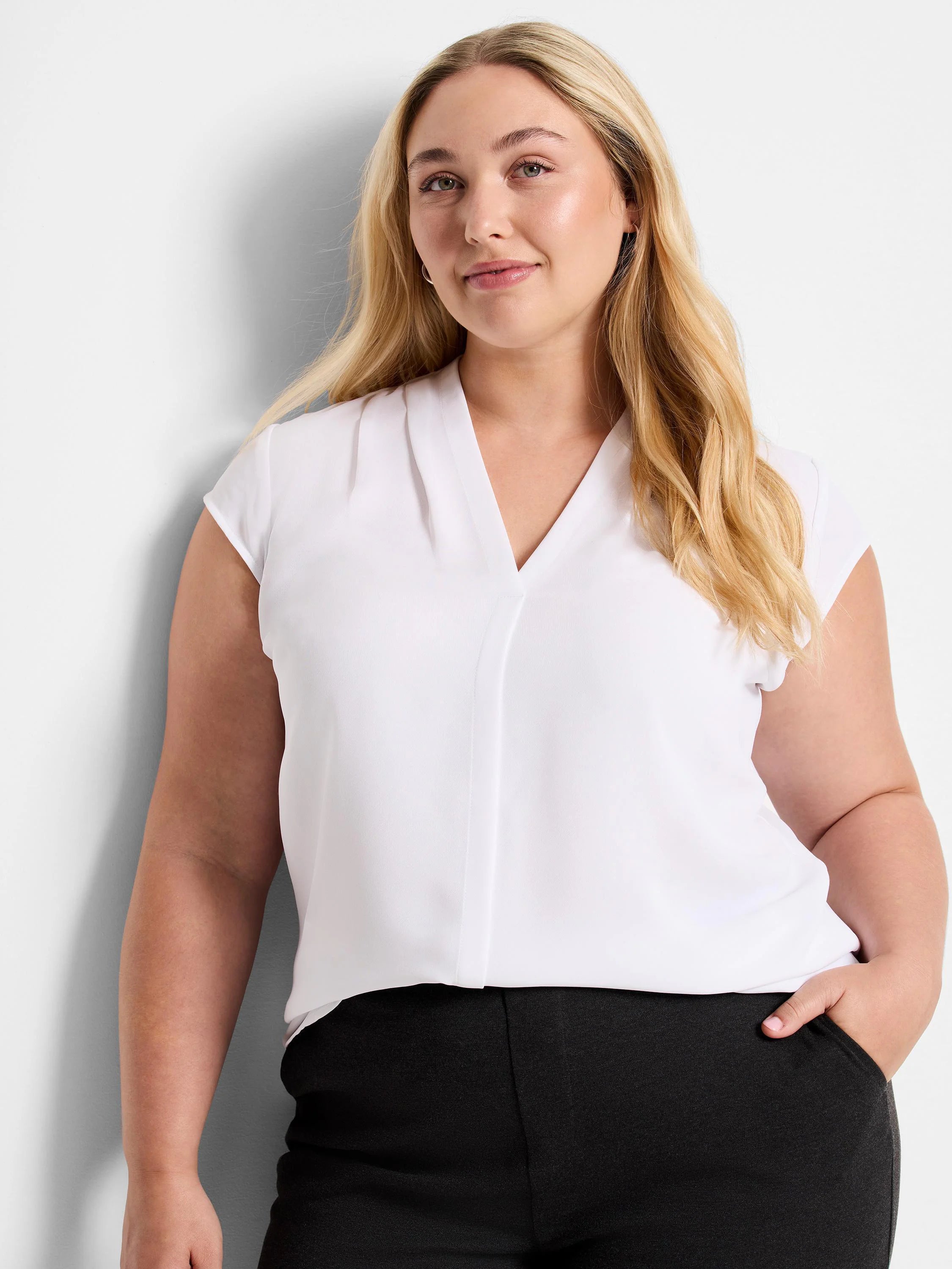 White cap sleeve V-neck top with soft front pleats and a subtle center seam.