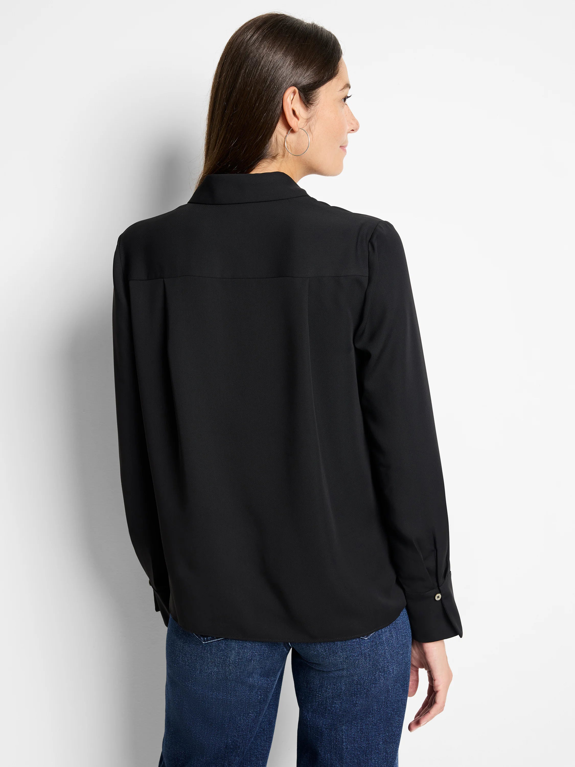 Black popover shirt. Long sleeves with light button cuffs, collared, relaxed fit, and a back yoke detail.