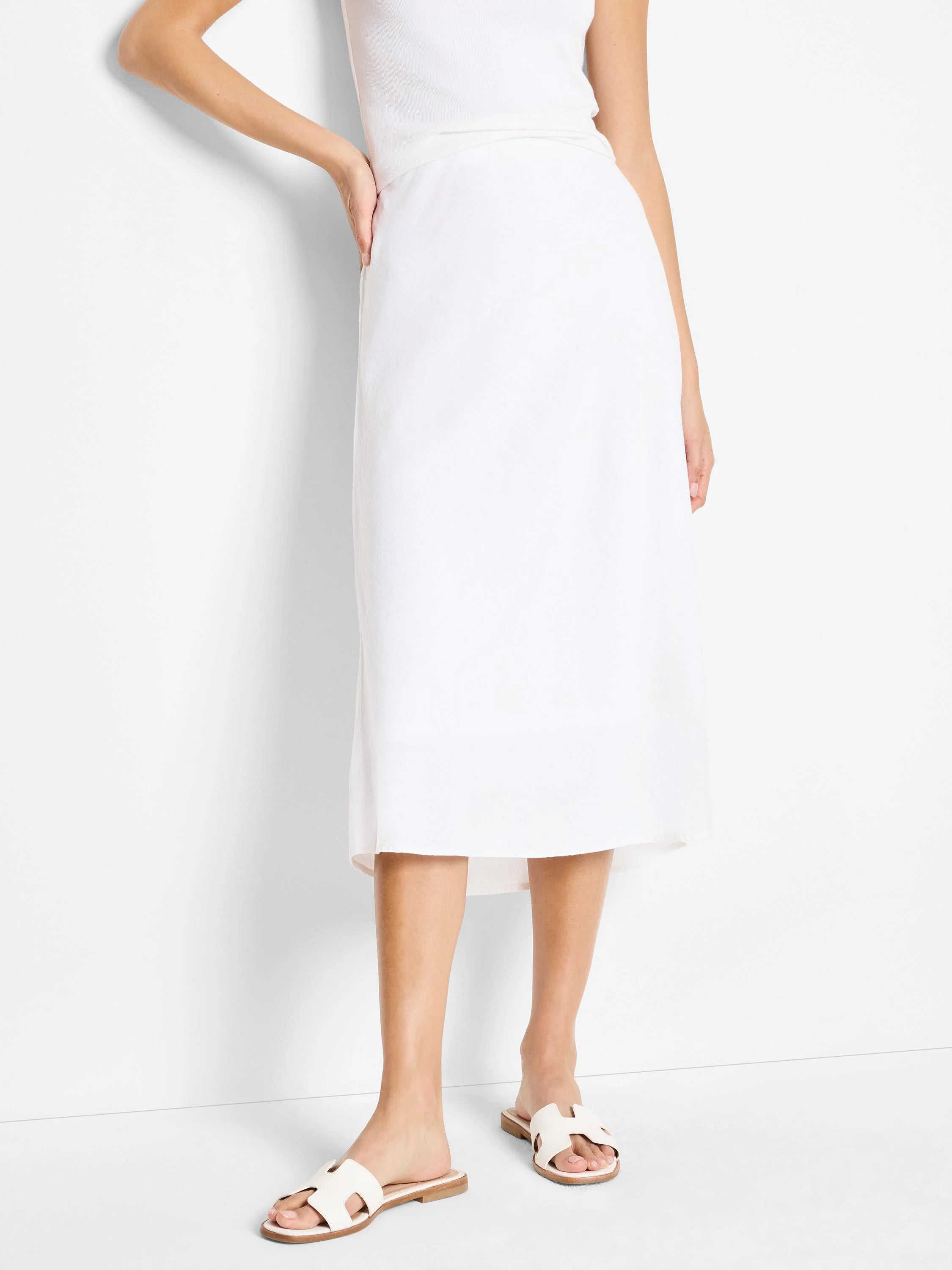 White midi length linen slip skirt with a straight fit and subtle texture.