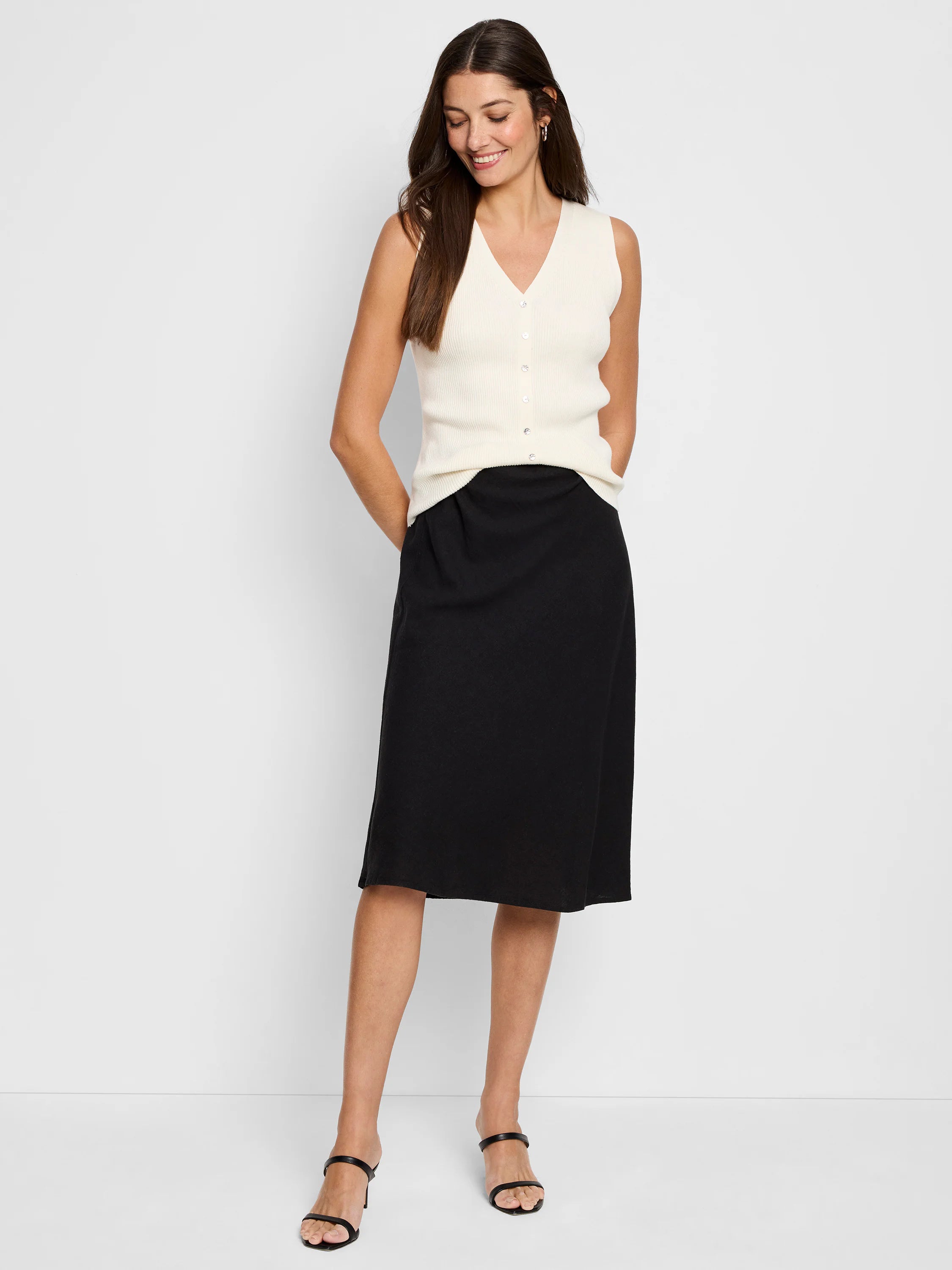 Black A-line midi skirt on a model. The skirt is shown with an off-white top.