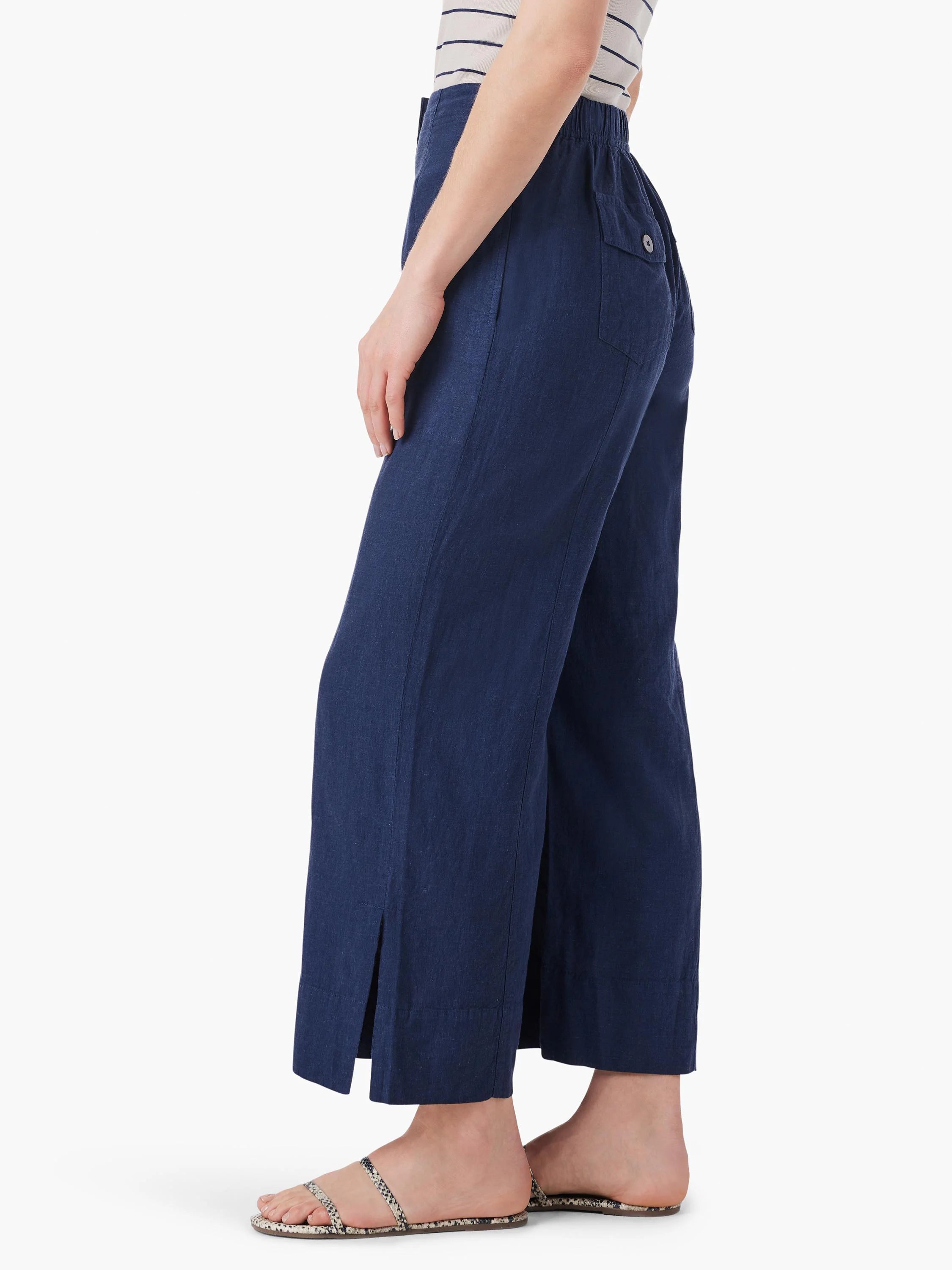 Dark blue wide-leg crop pants with elastic waist, buttoned back pocket, and side-slit hems on model.