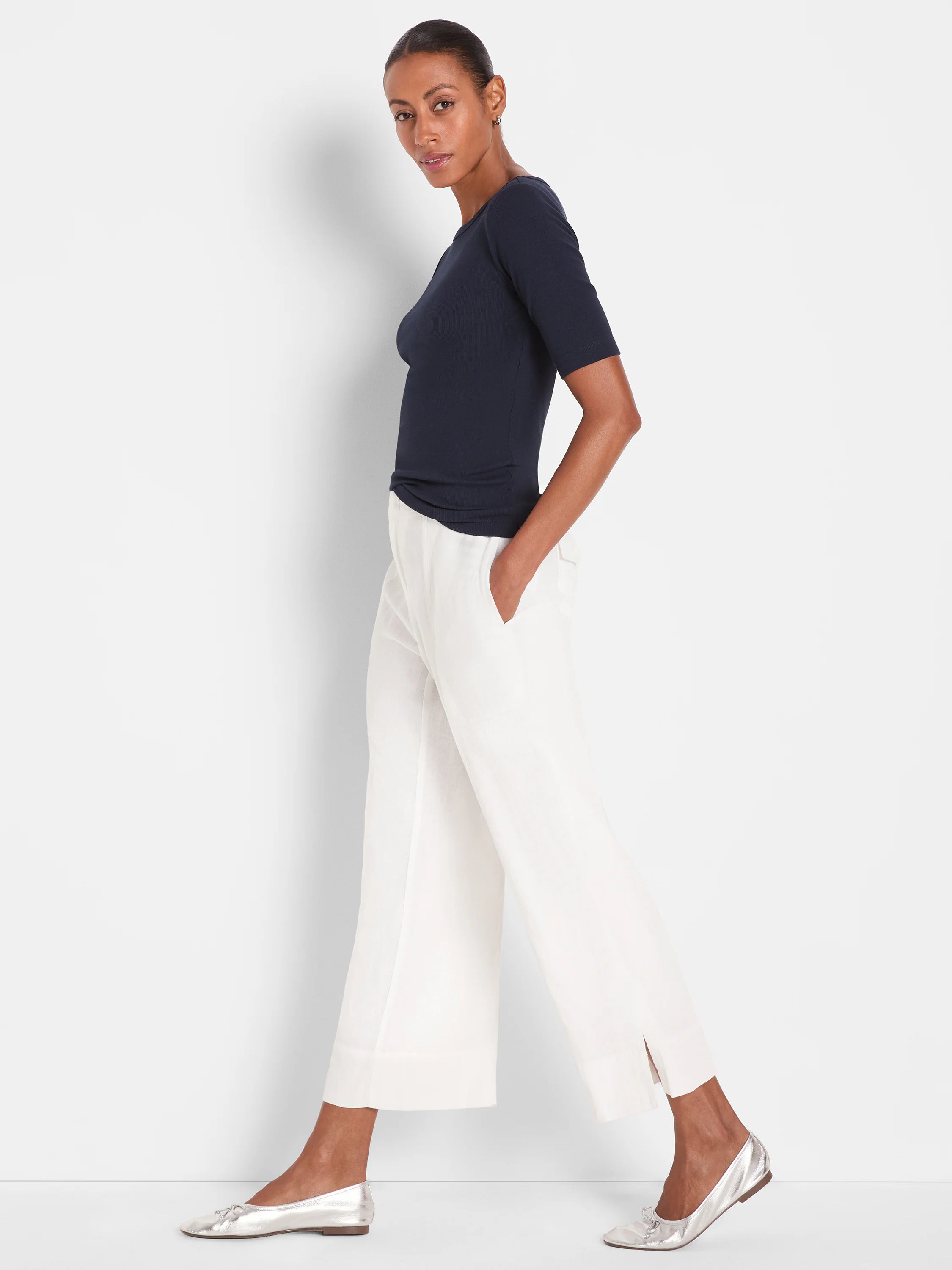 Off-white wide-leg crop pants with subtle ankle slits.