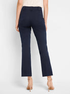 Dark blue demi-boot cropped pants seen from behind, featuring back patch pockets and belt loops.