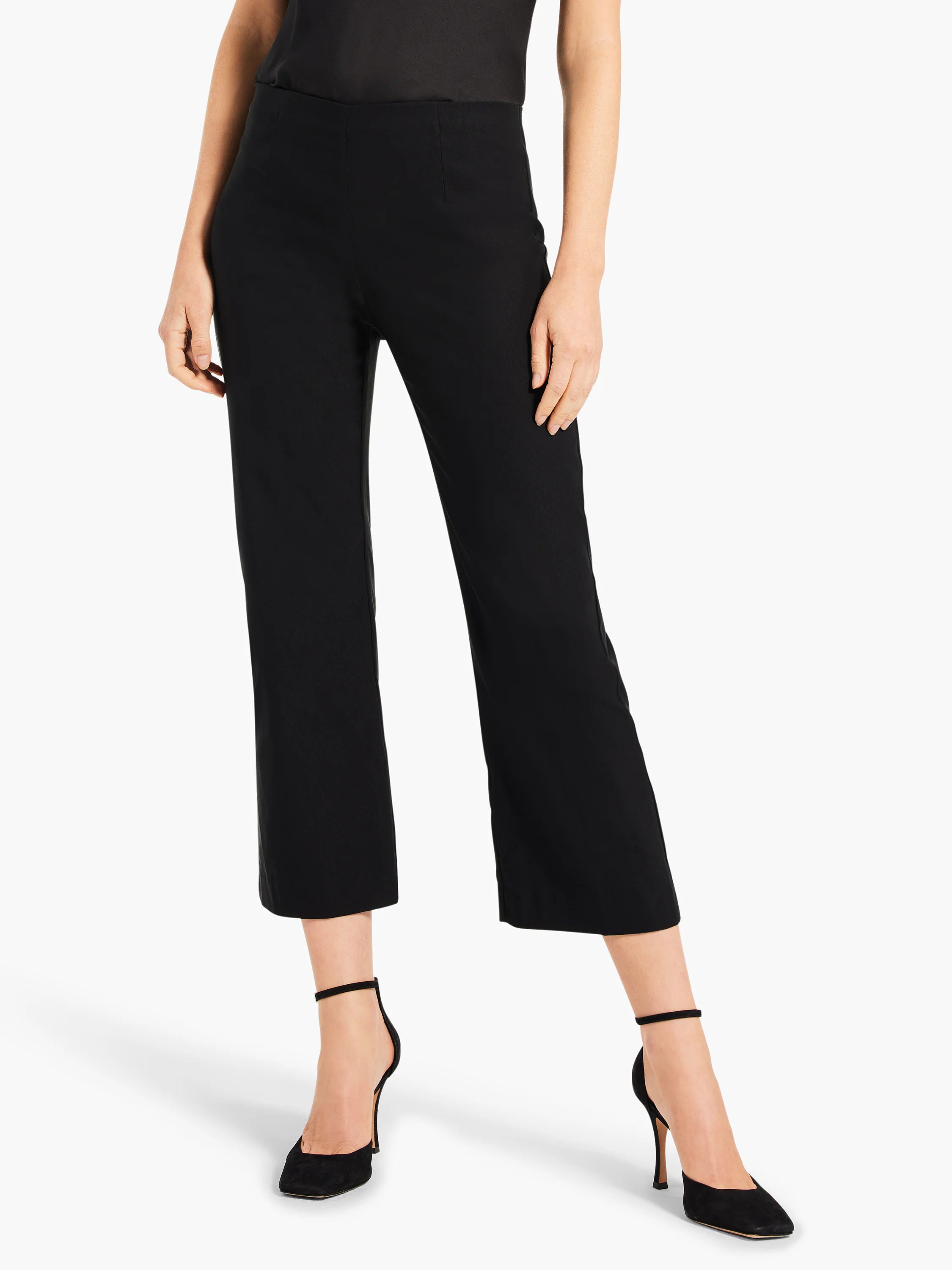 Black, high-waisted wide-leg crop pants. Smooth fabric, cut above the ankle, worn with black heels.