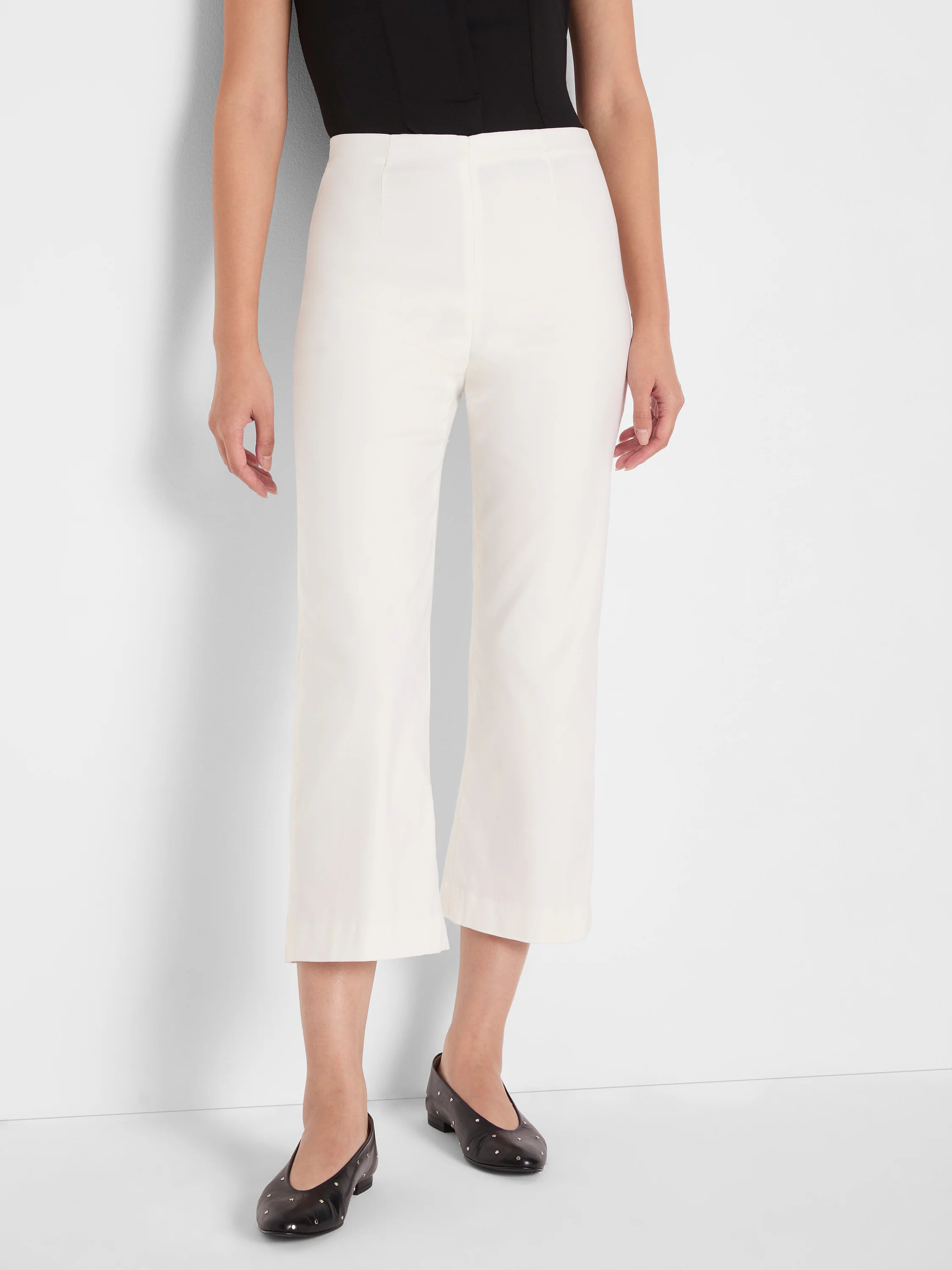 Off-white wide-leg crop pants with a smooth finish, worn high-waisted and ending at mid-calf.