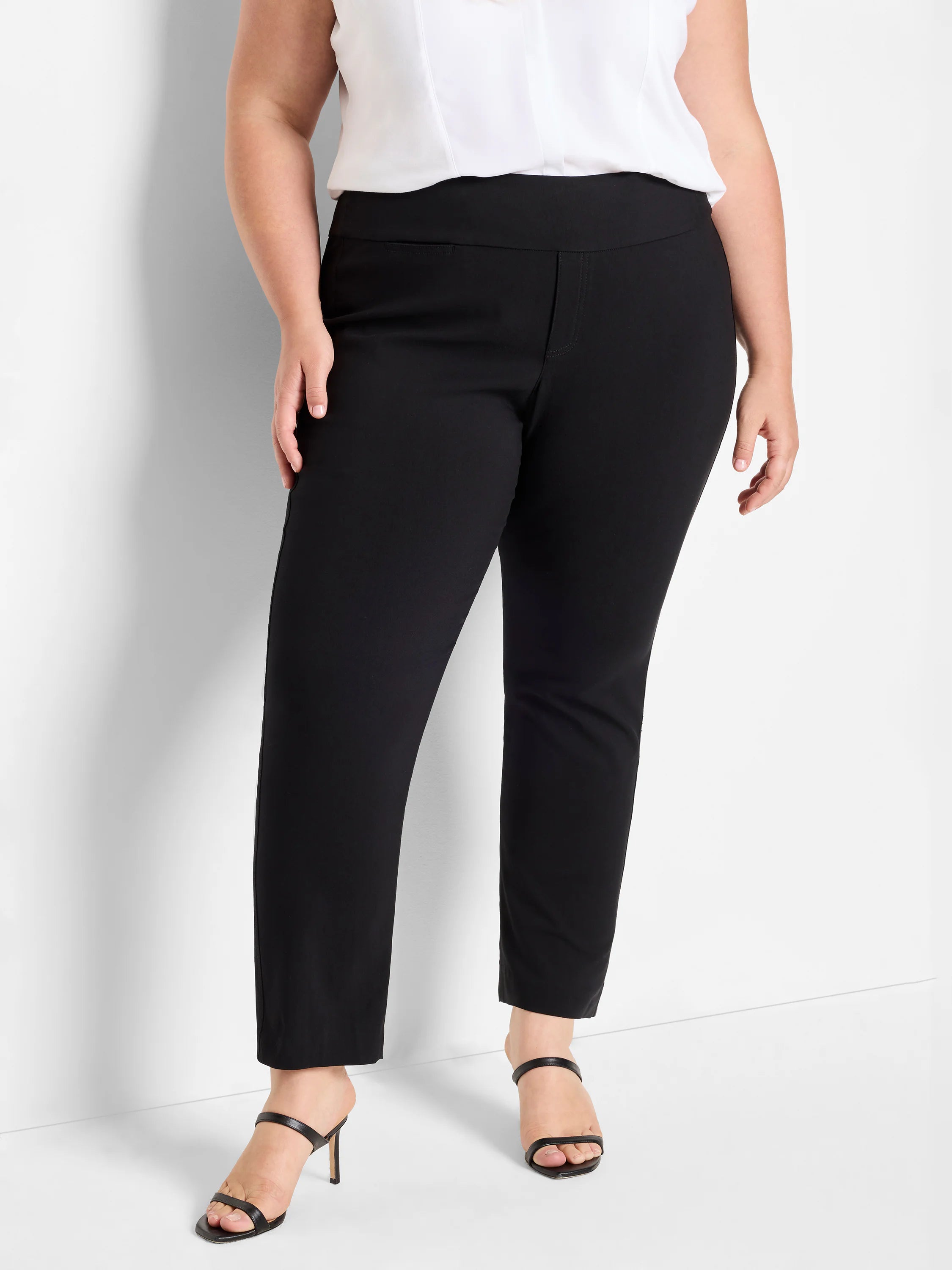 Black straight leg pants with a smooth, pull-on waistband and a small horizontal hip pocket. Ankle length.