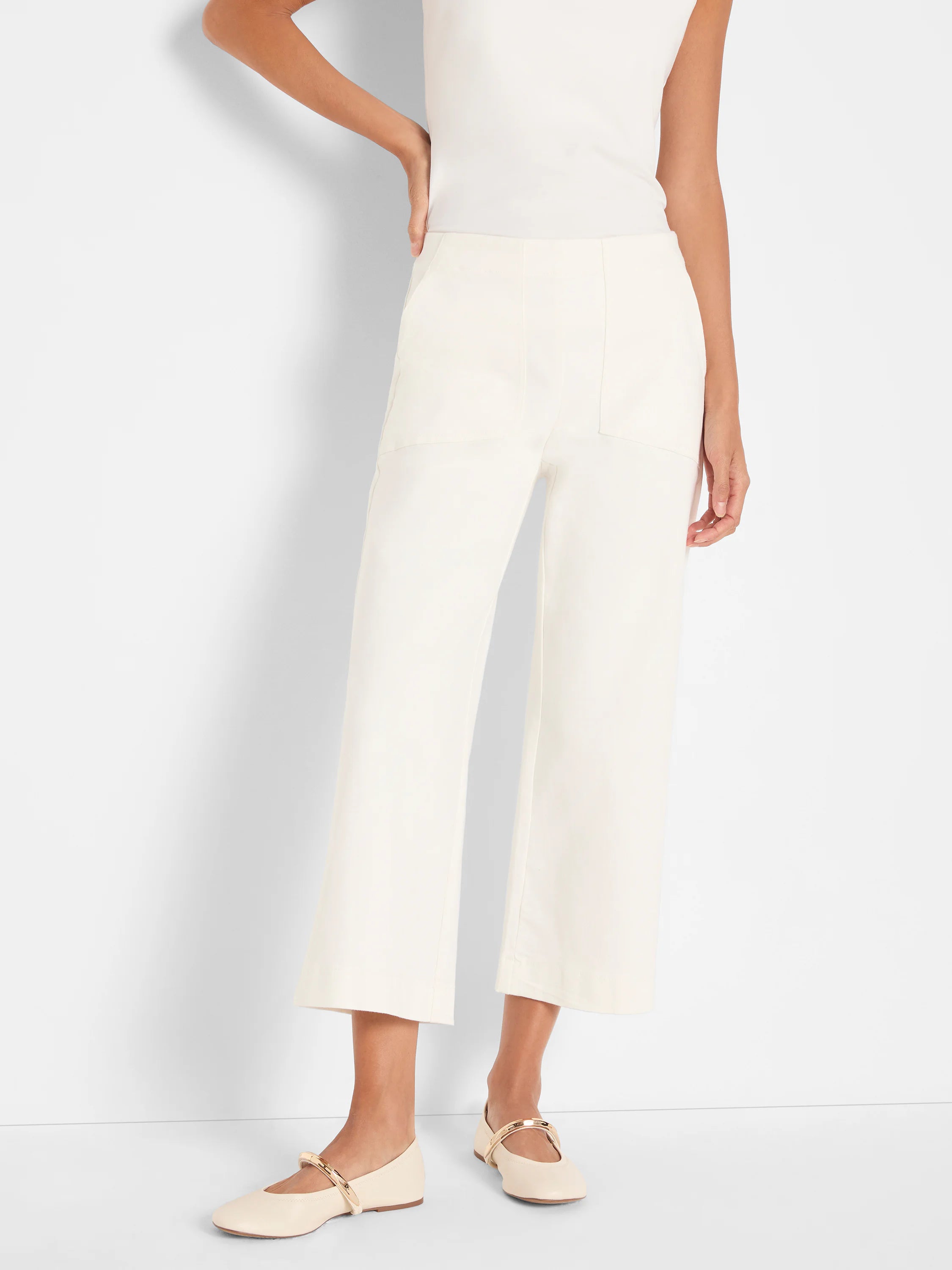Cream wide-leg cropped jeans with large front patch pockets and visible seam detailing.