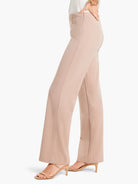 Light beige wide-leg trousers with a subtle front seam and side zipper, on a model wearing nude heels.