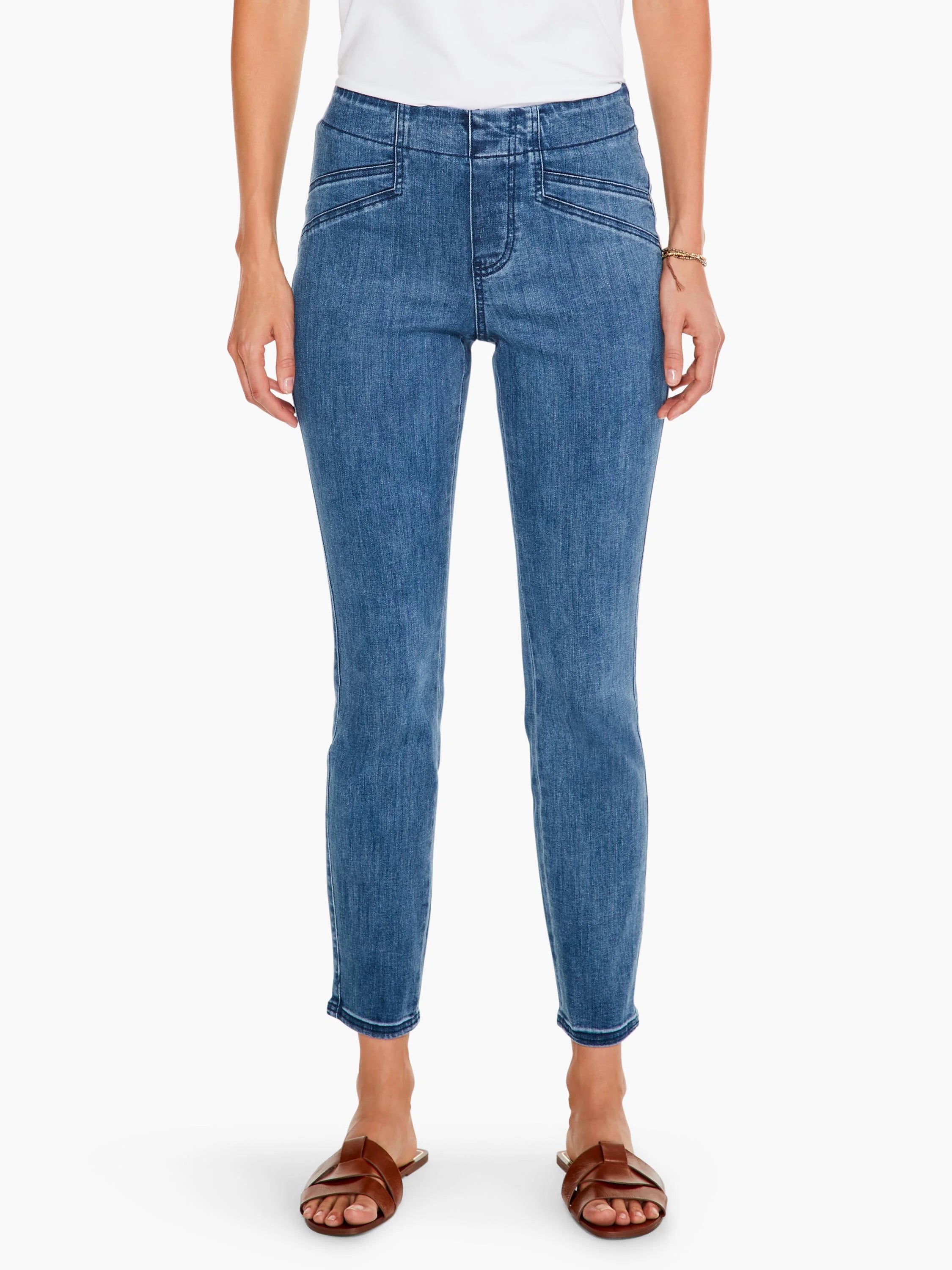 Medium blue slim jeans. High-waisted, pull-on style with decorative front seams and faux pockets. Cropped ankle length.