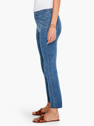Medium blue slim jeans, cropped at the ankle, with angled front seams and small silver rivets.