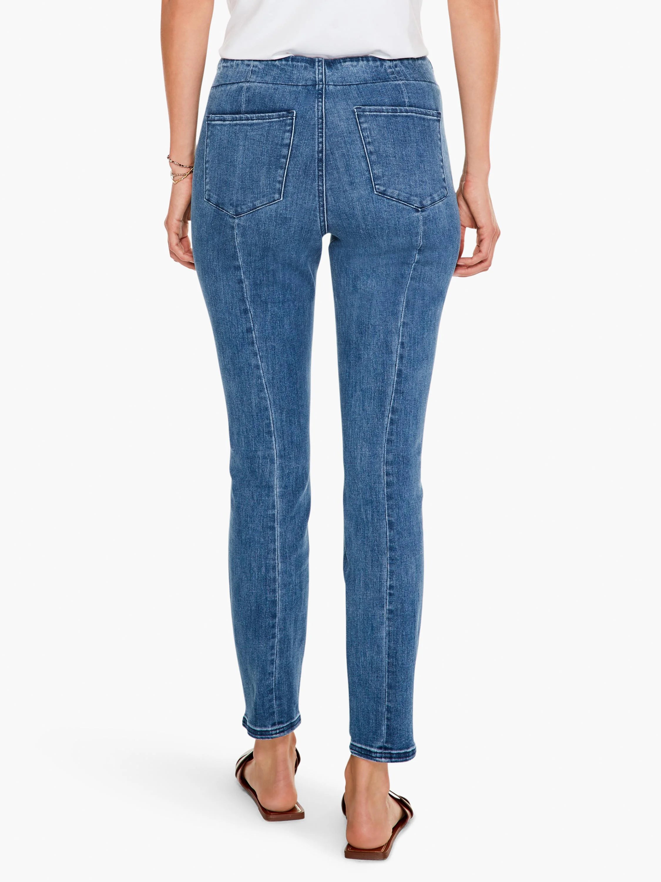 Medium blue slim jeans, back view, with visible back pockets and vertical seams down each leg.