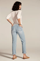 Light blue wash jeans with relaxed leg, cuffed hem, and distinctive back pocket stitching. Subtle fading is visible.