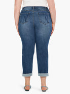 Medium blue girlfriend jeans, mid-rise, with faded areas, stylized back pockets, and cuffed ankles.