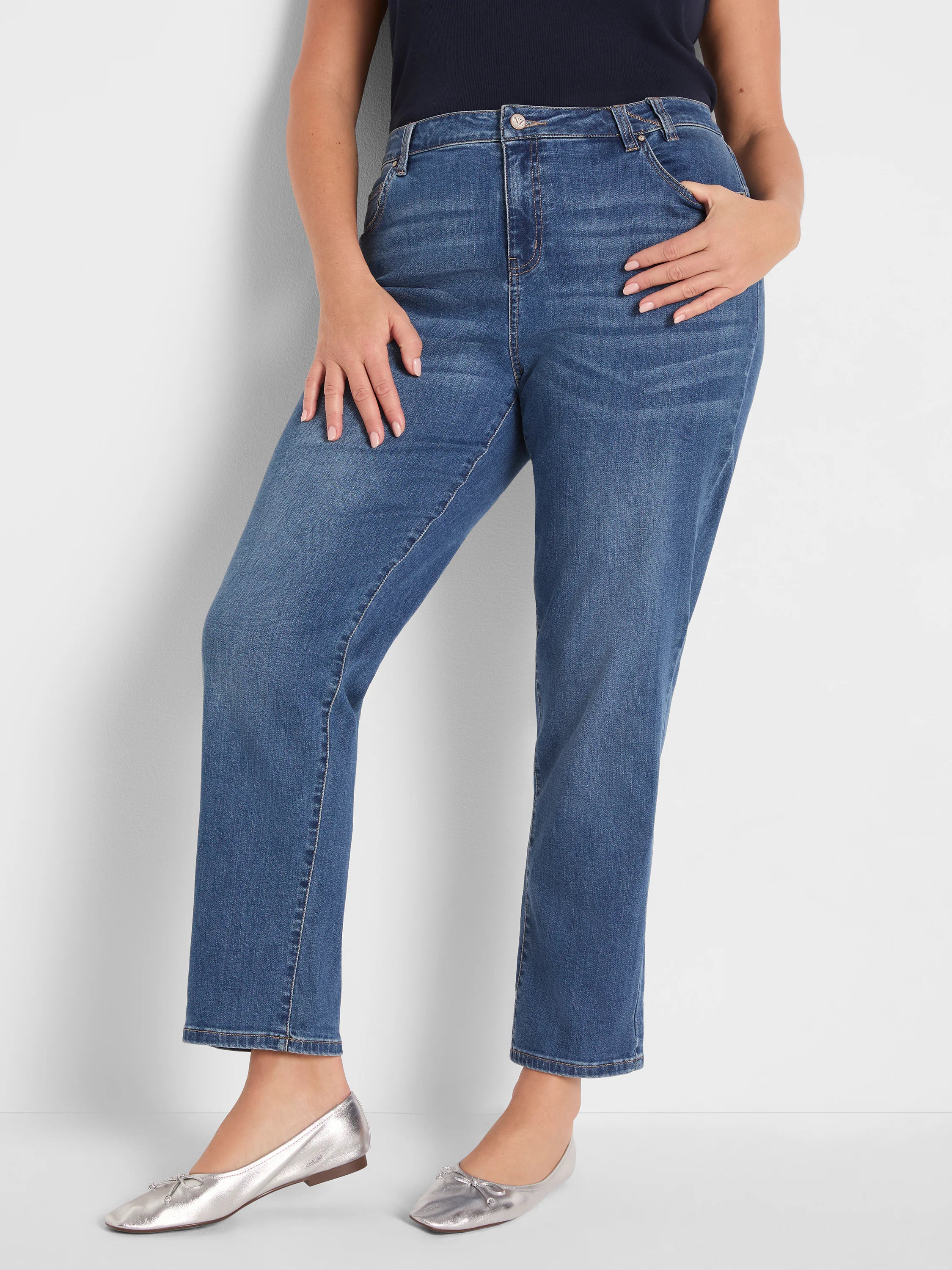 Medium blue mid-rise girlfriend jeans with a relaxed, slightly cropped leg and classic denim details.