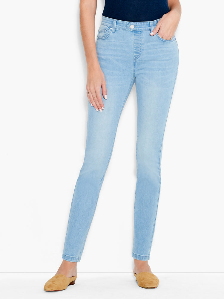 The model wears light wash, slim-fit denim jeans featuring a classic five-pocket design.