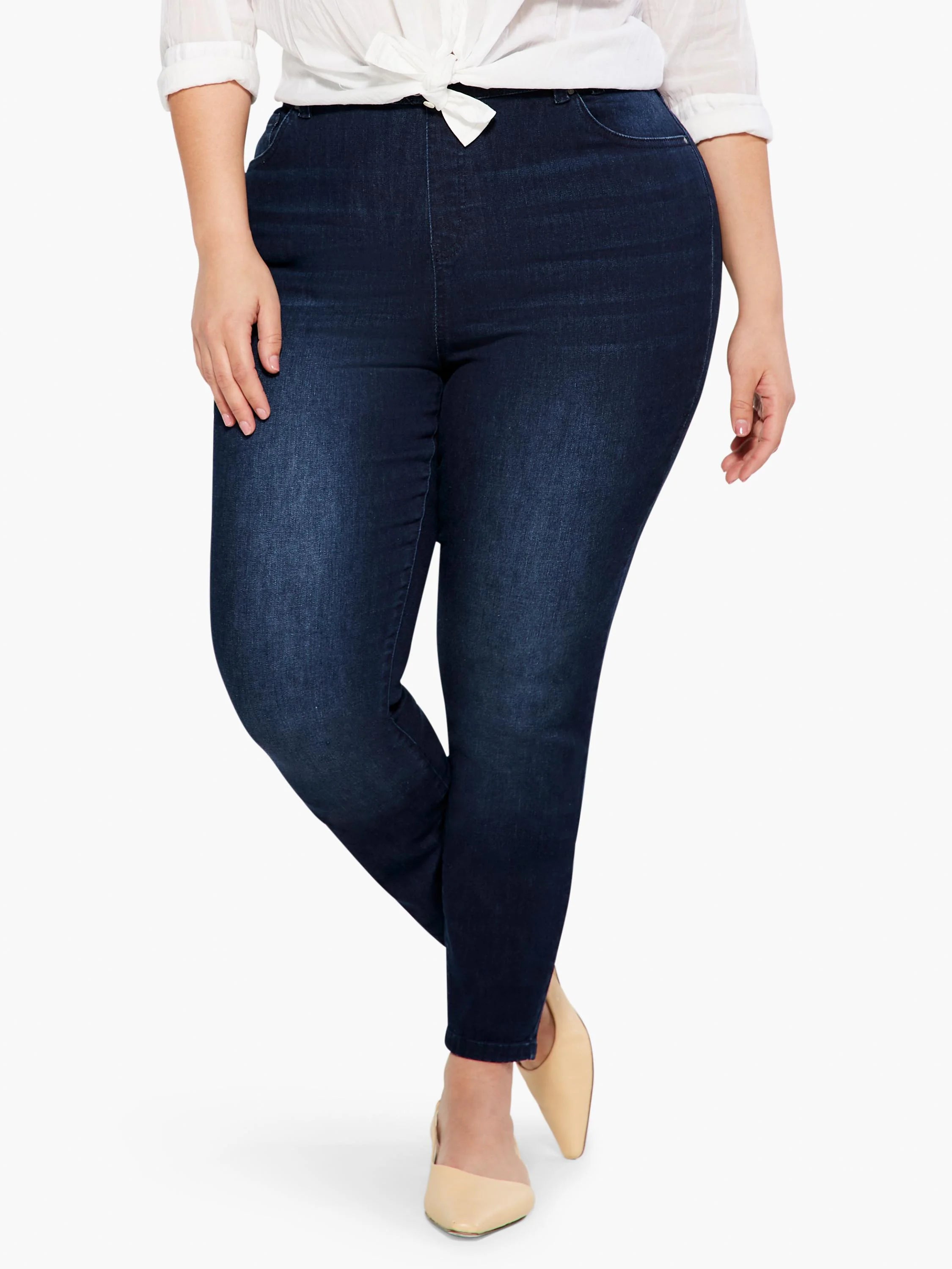 Dark blue denim slim ankle jeans with a faded wash, worn by a plus-size model from waist to ankle.