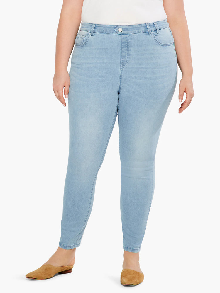 Light blue, mid-rise slim ankle jeans on a model. Jeans are a lighter wash denim.