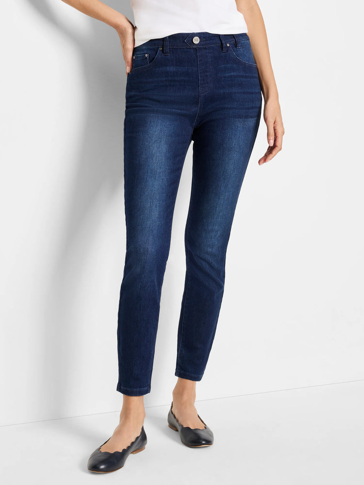 Dark wash, mid-rise slim ankle jeans on a model. The jeans are a deep blue.