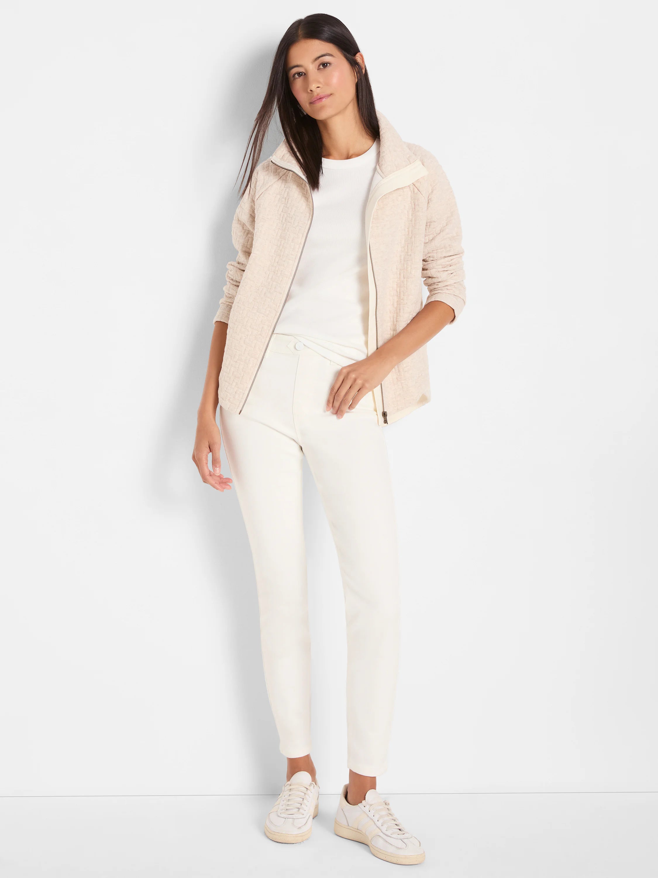 Off-white slim ankle jeans with a smooth texture and a vertical seam down the front of each leg.