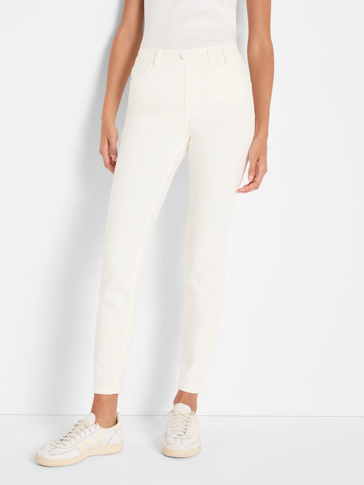 Off-white slim ankle jeans on a model, featuring a front button closure and pockets.
