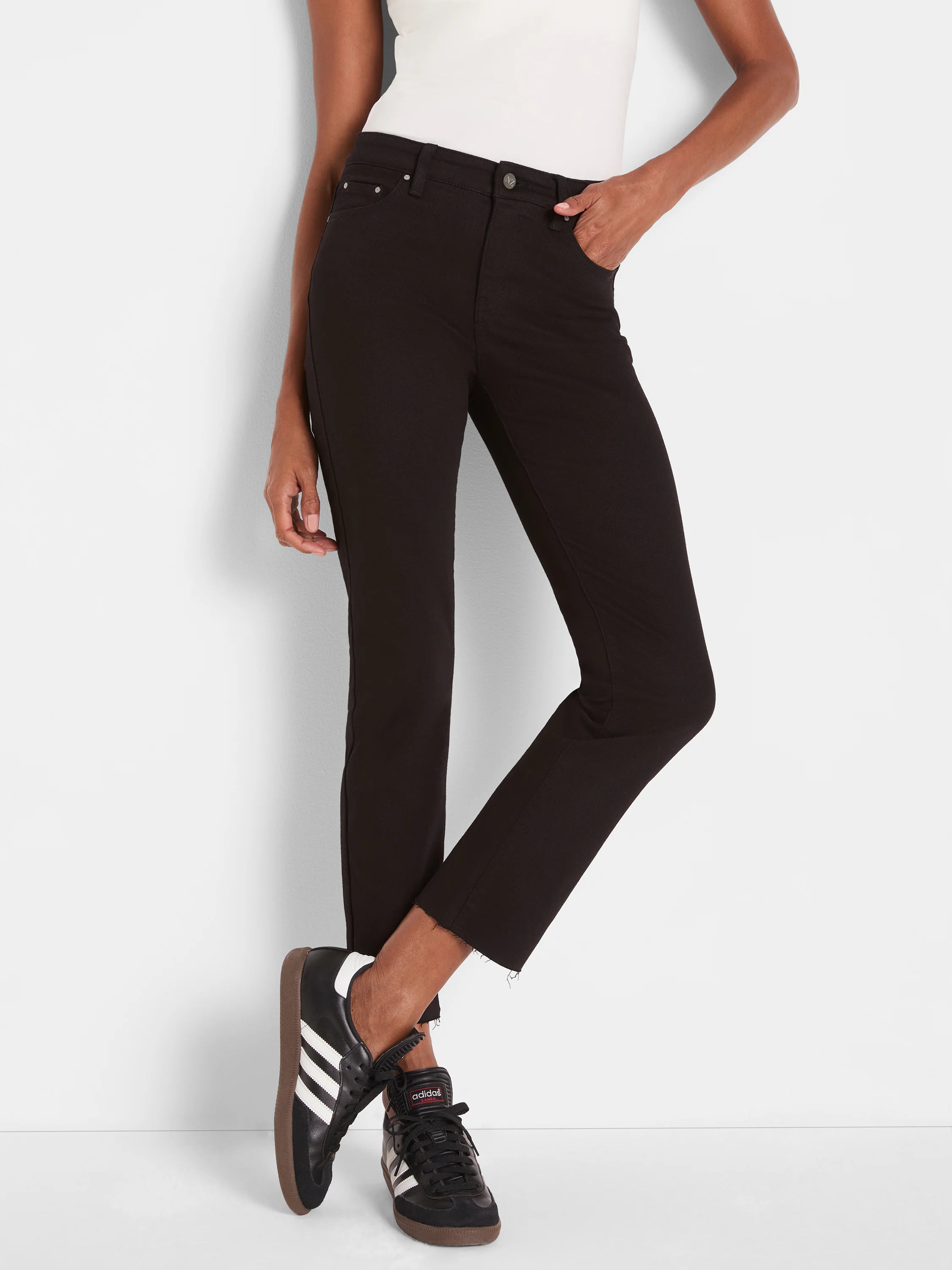 Black straight ankle jeans with a raw hem, worn by a model.