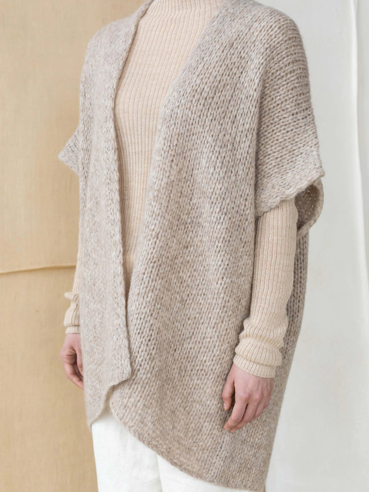 Beige knit vest, open front, short sleeves. Slightly irregular texture.