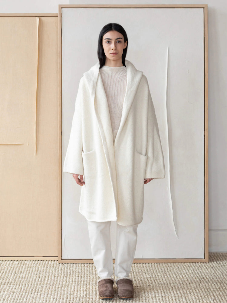 Off-white hooded alpaca coat; long sleeves, patch pockets, open front.
