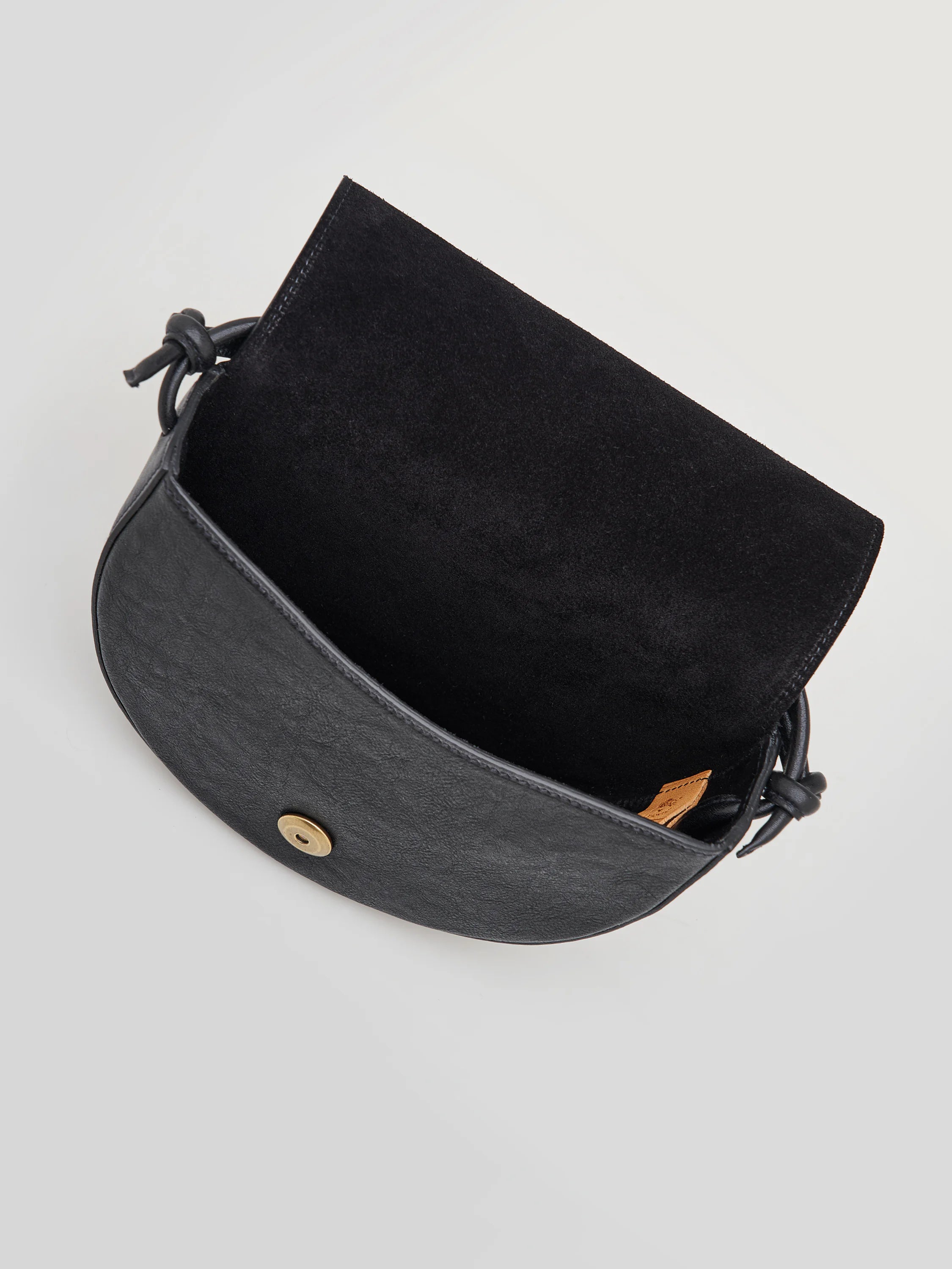 Black half-moon crossbody bag with black suede interior, knotted leather straps, and gold-toned clasp.