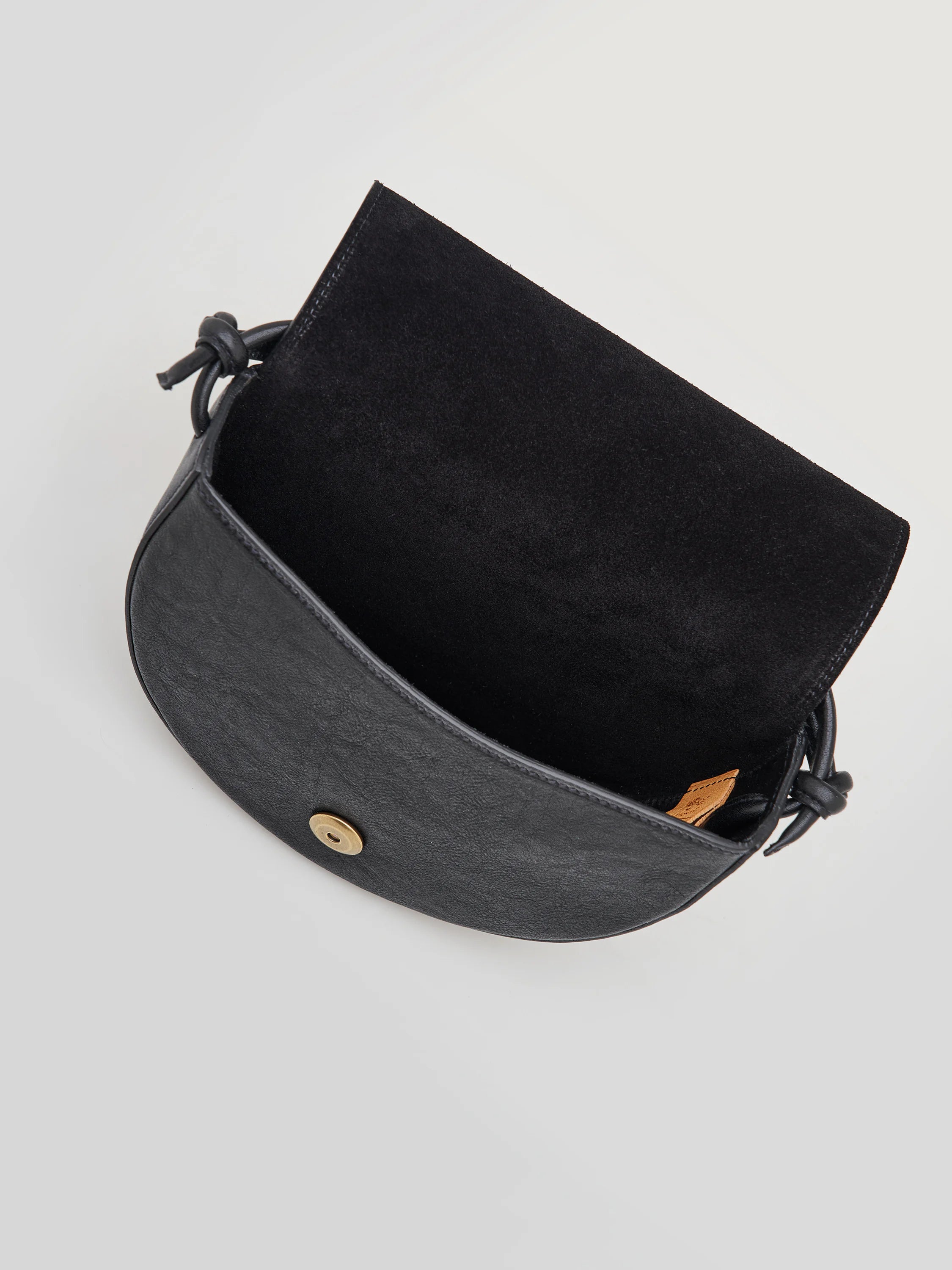 Black half-moon crossbody bag with knotted strap, black suede interior, and gold clasp.
