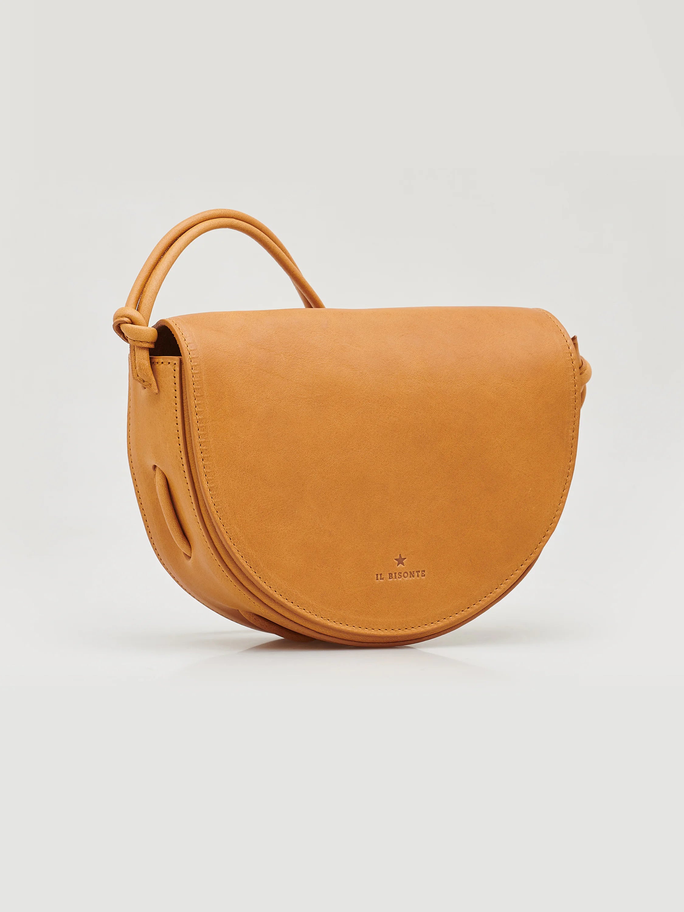 Light brown leather half-moon crossbody bag with a small top handle. Subtle logo.
