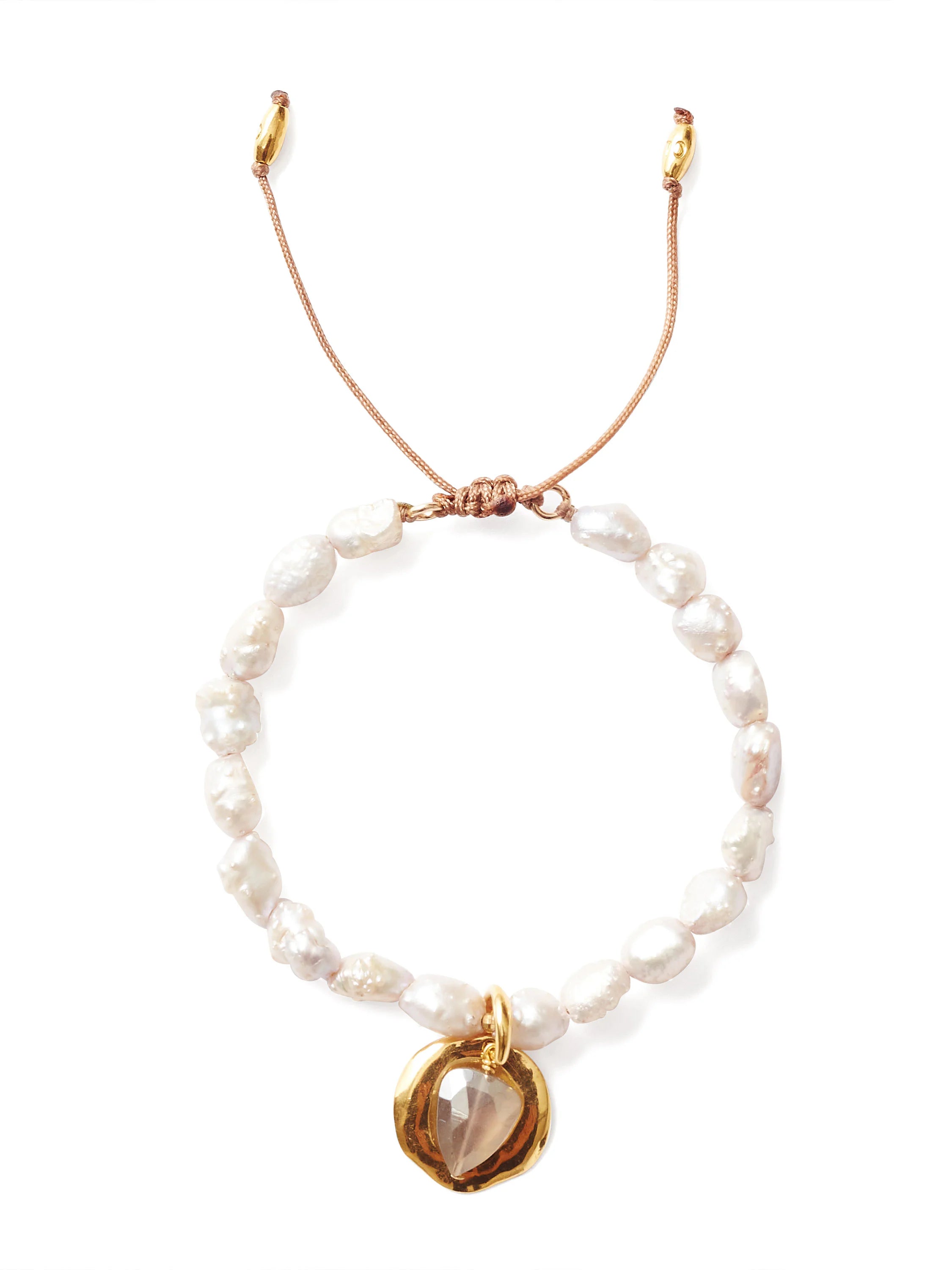 Irregular white pearl bracelet on a beige adjustable cord. Features a gold disc charm with a faceted pale stone.