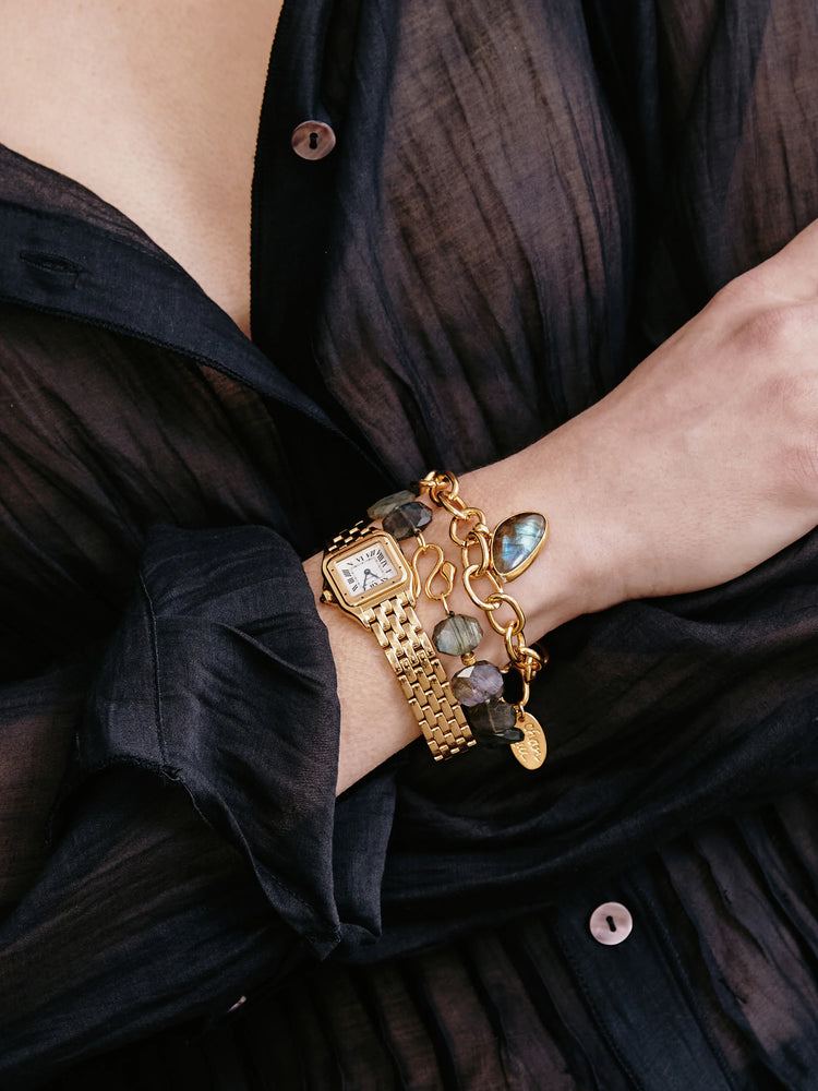 Gold chain bracelet with labradorite and gold charms. Dark gray/blue stones. Gold-tone metal.