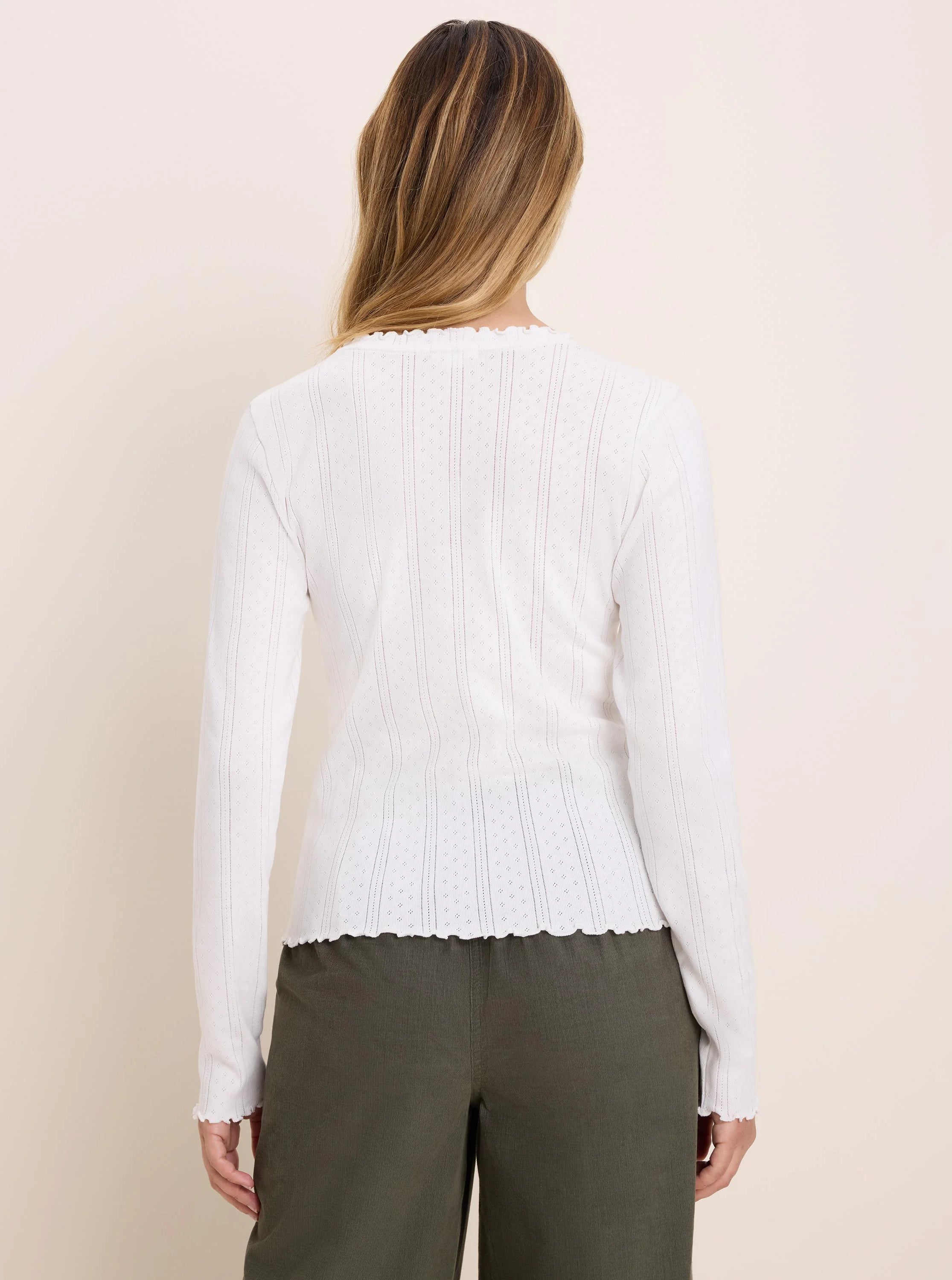 White long sleeve tee, back view. Pointelle rib fabric: vertical rows of tiny diamond perforations. Scalloped neck,...