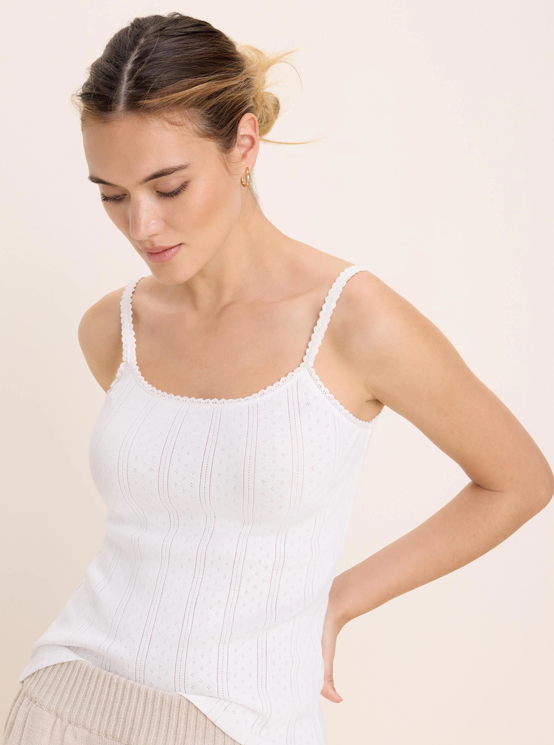 White pointelle rib cami, fitted with vertical ribbed pattern, small diamond perforations, and scalloped lace trim.