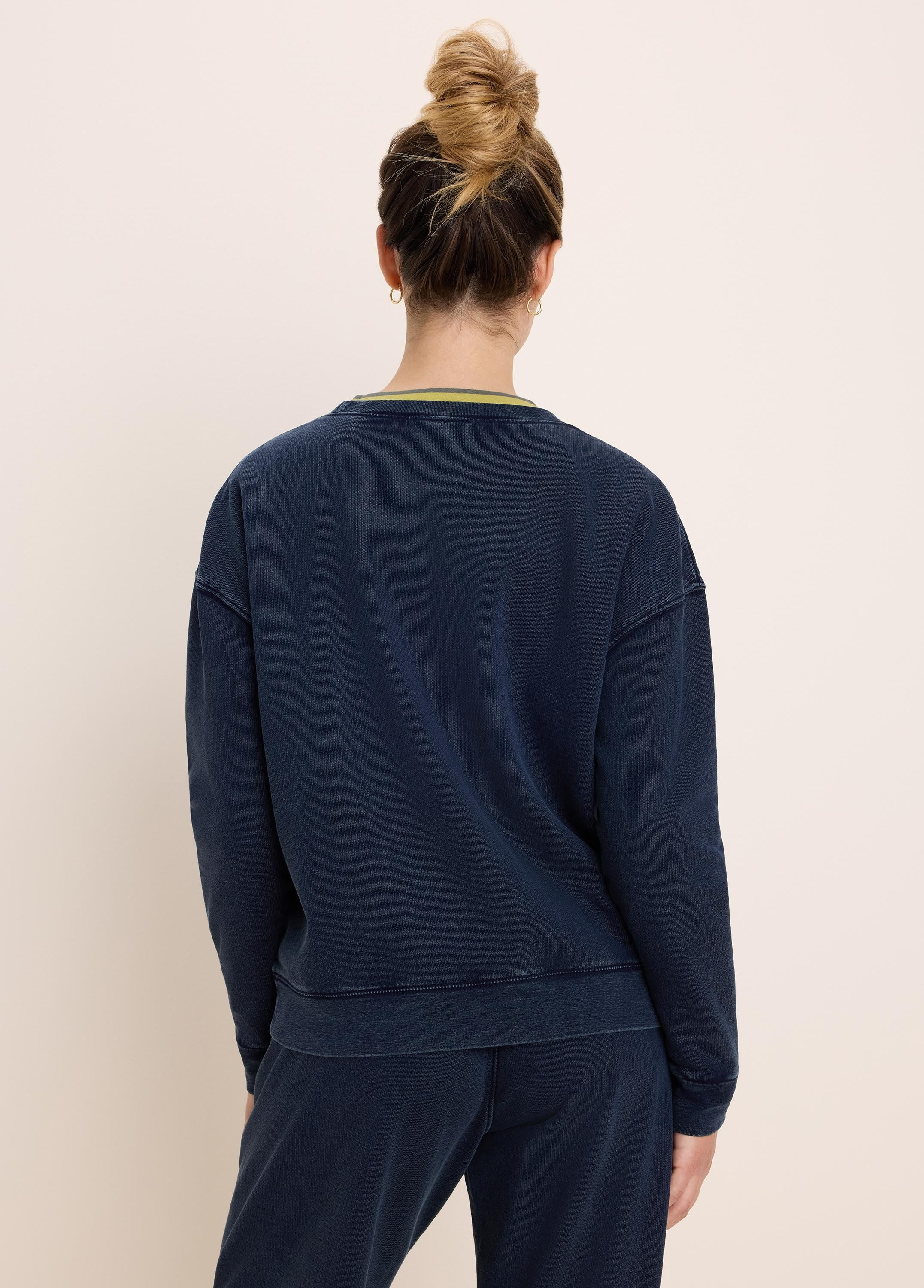 Washed navy cotton terry crewneck sweatshirt with visible stitching detail and a green stripe at the inner back collar.
