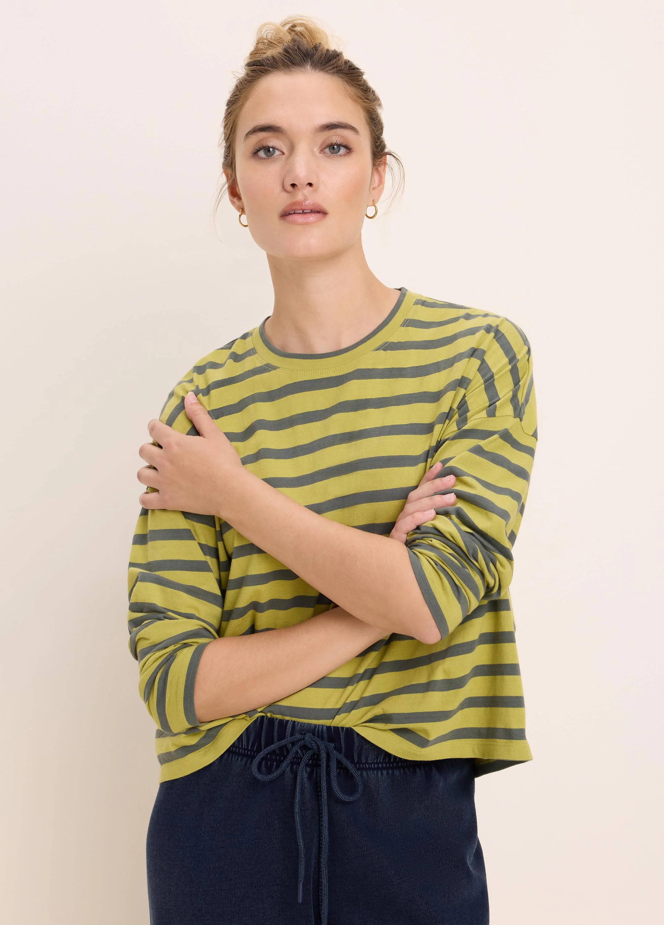 Relaxed fit, long-sleeve, crew neck tee with horizontal greenish-yellow and dark gray stripes.