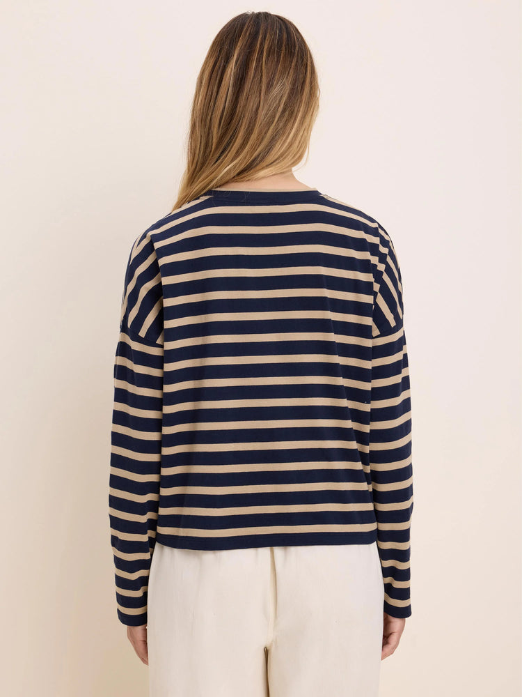 Long-sleeved tee with horizontal navy blue and beige stripes. Model from behind.