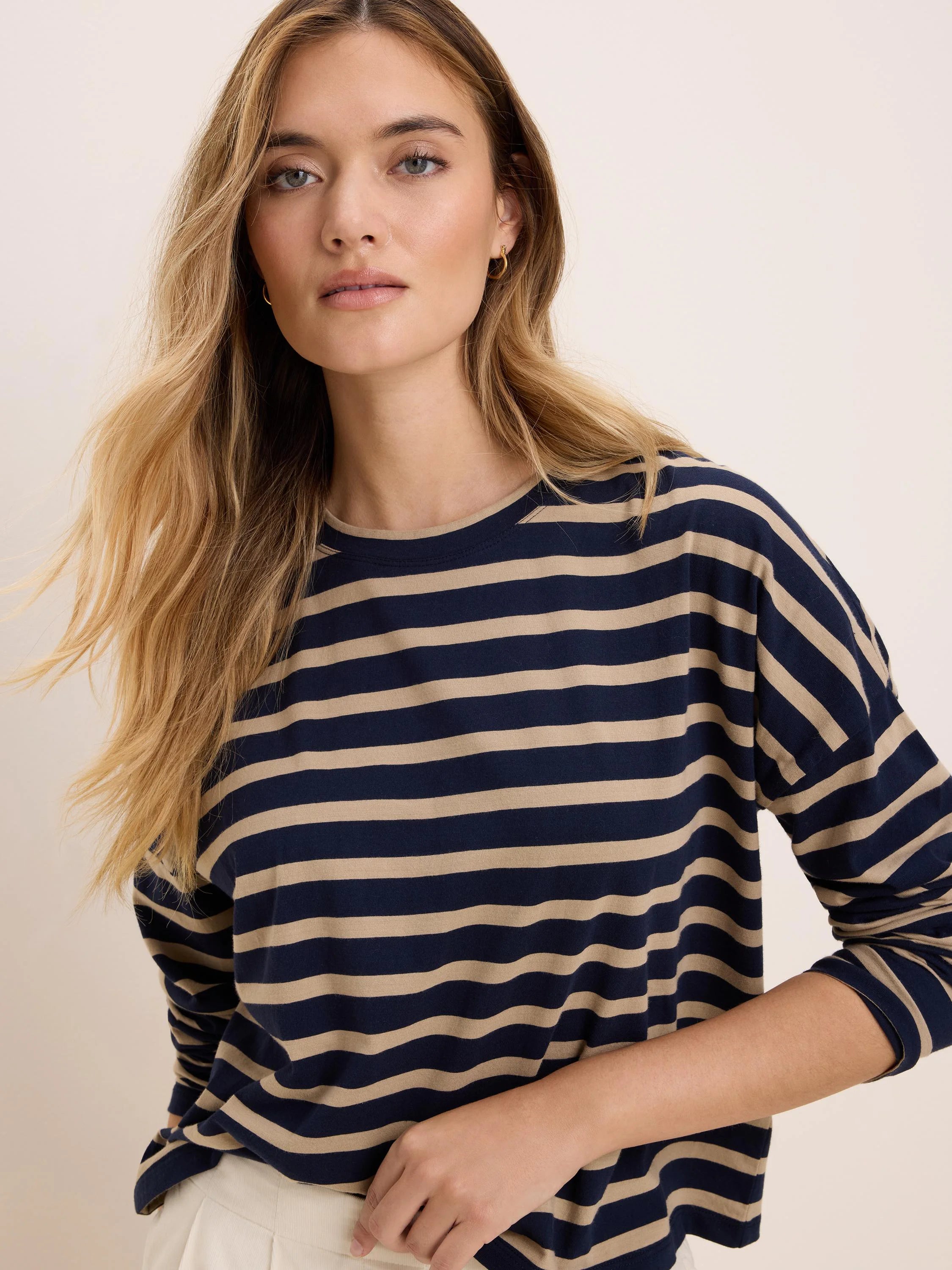 Long-sleeve tee with navy and tan horizontal stripes, crew neck, and relaxed fit.