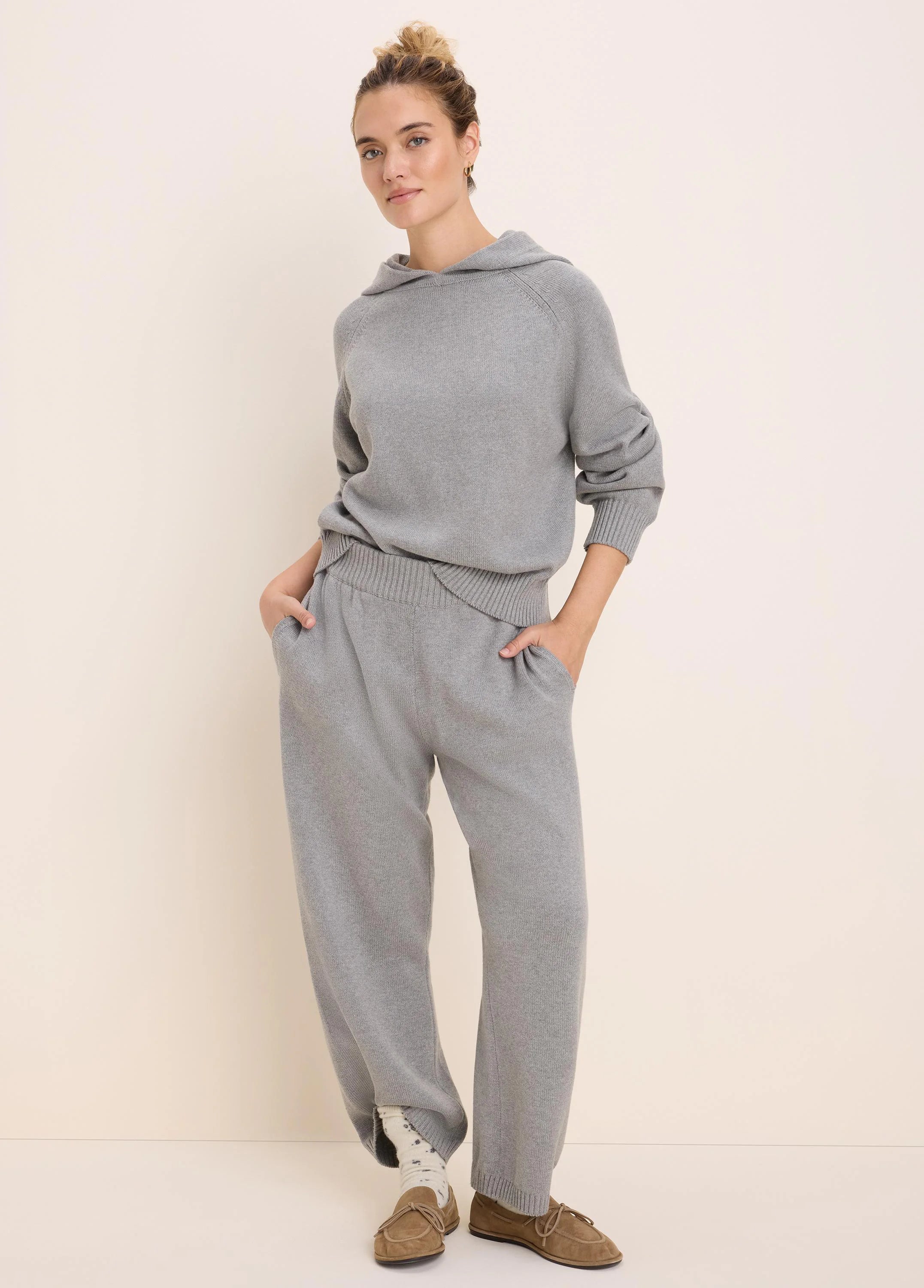 Light grey knit hoodie with a hood, raglan sleeves, ribbed cuffs and hem. Worn with matching knit pants.