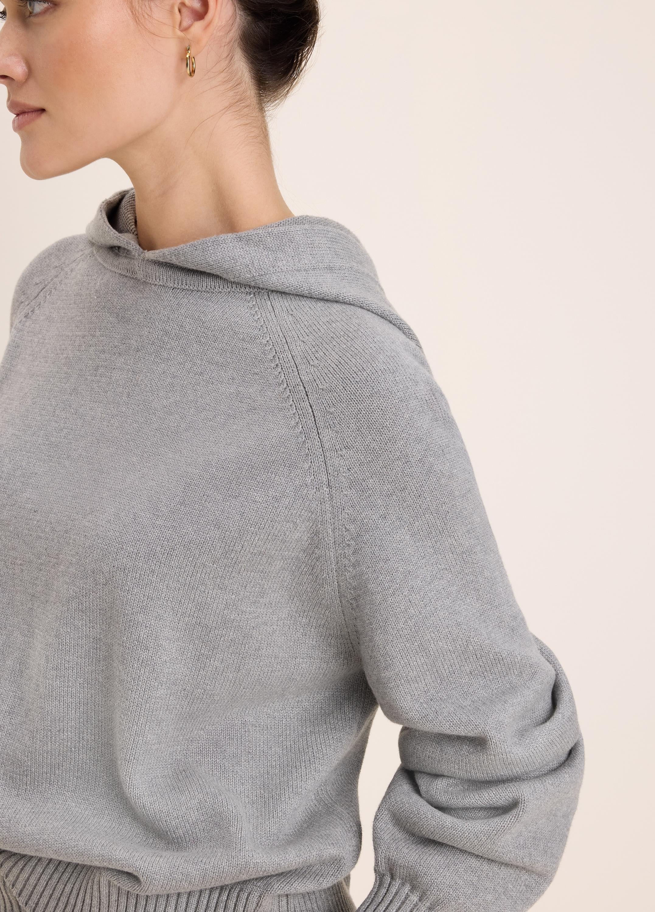 Heather grey knit hoodie with raglan sleeves and ribbed cuffs.