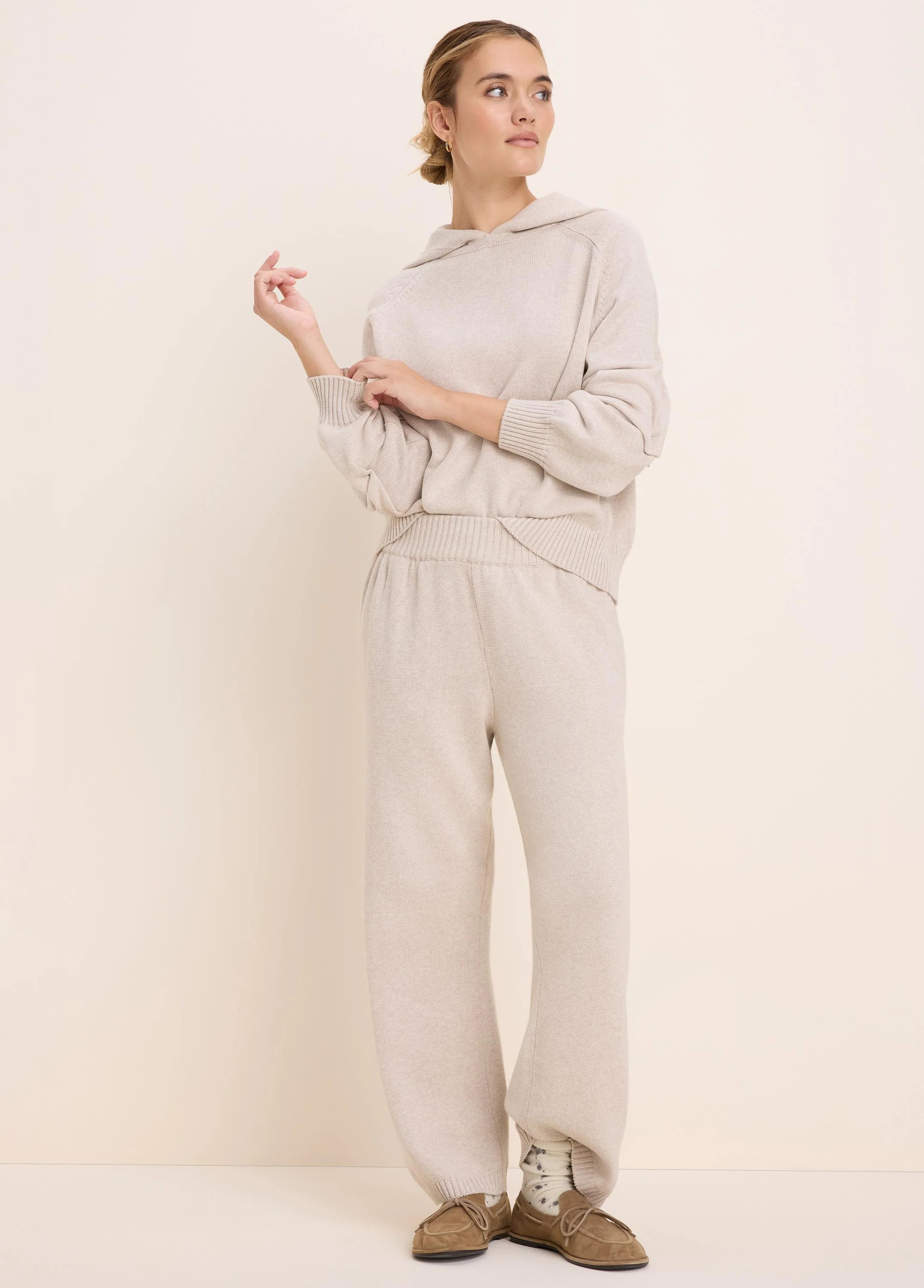 Loose-fit oatmeal knit sweater hoodie with an attached hood, long raglan sleeves, and ribbed cuffs and hem.