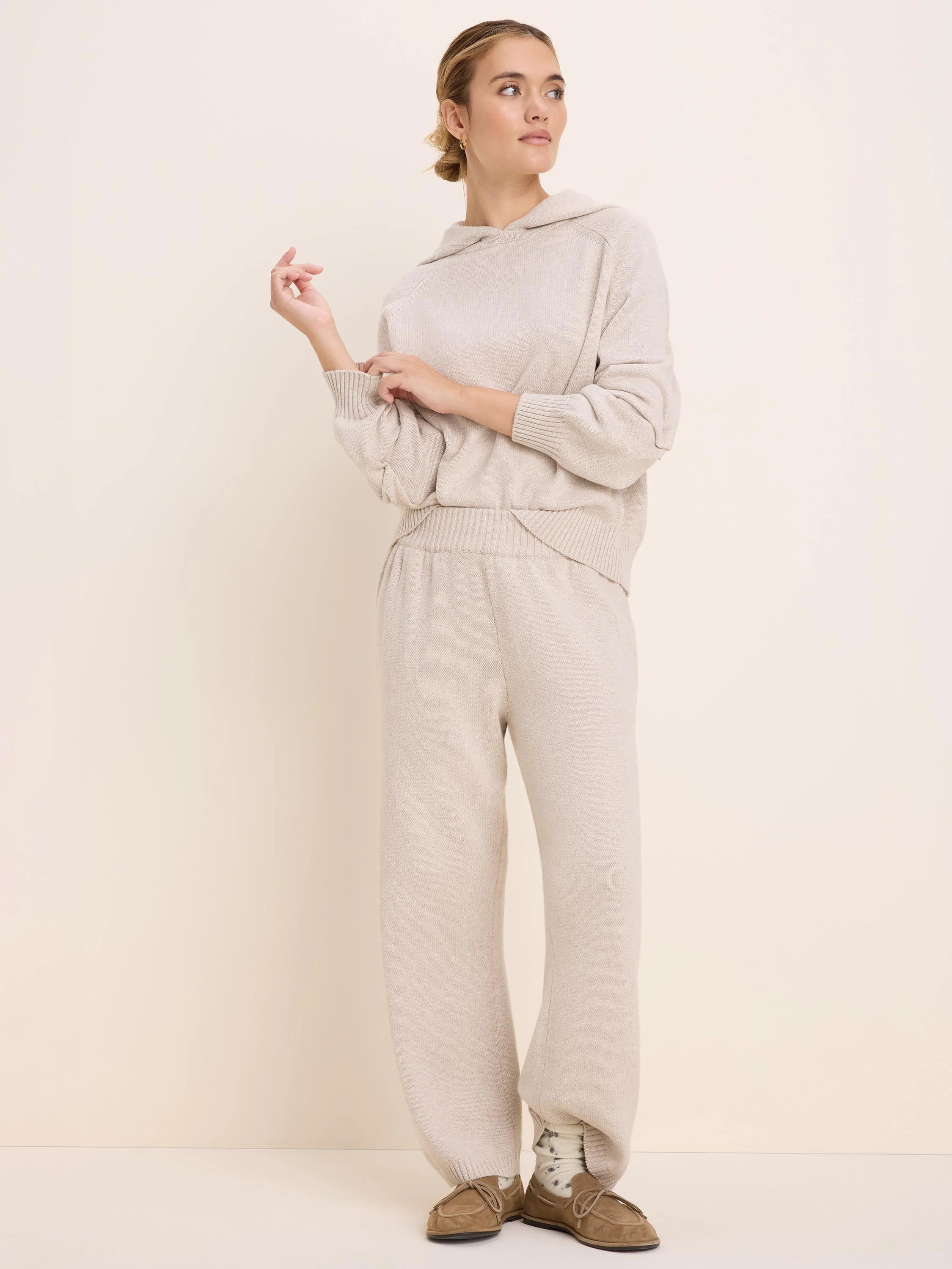 Loose-fit oatmeal knit sweater hoodie with an attached hood, long raglan sleeves, and ribbed cuffs and hem.