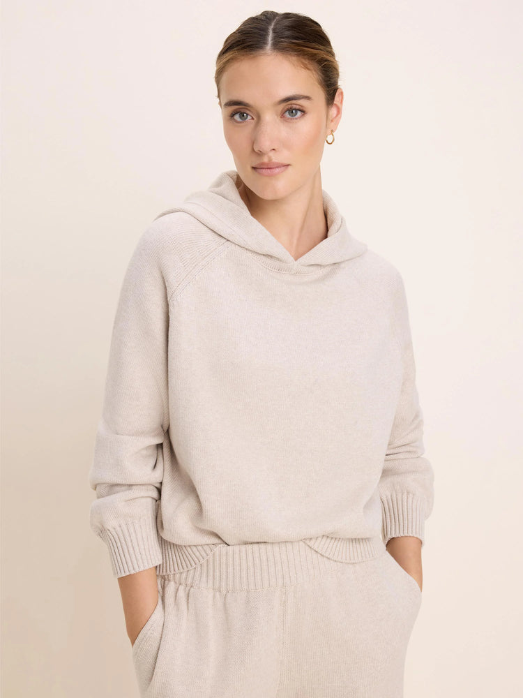 Light beige knit sweater hoodie with raglan sleeves, ribbed cuffs, and hem. Appears soft.