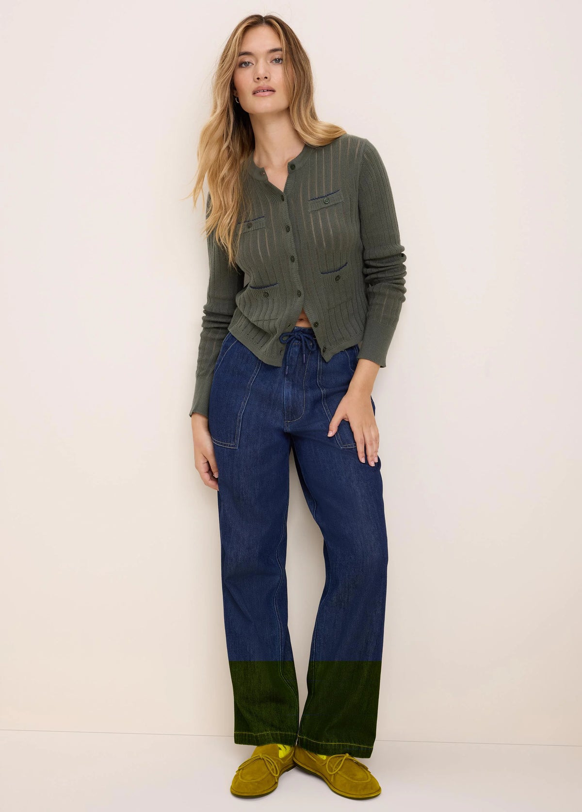 Olive green pointelle knit cardigan with a button-front and two buttoned chest pockets.
