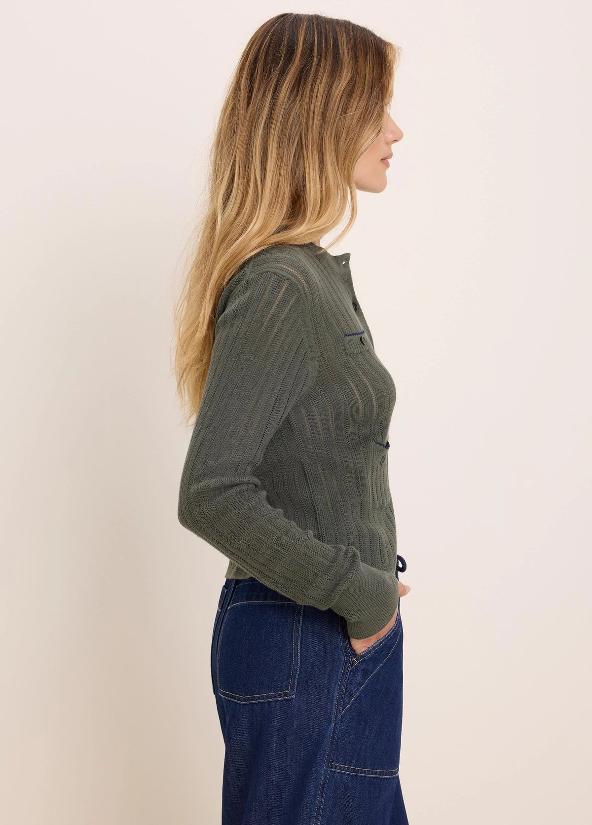 Olive green button-up cardigan with pointelle knit vertical stripes and a small chest pocket with blue trim.