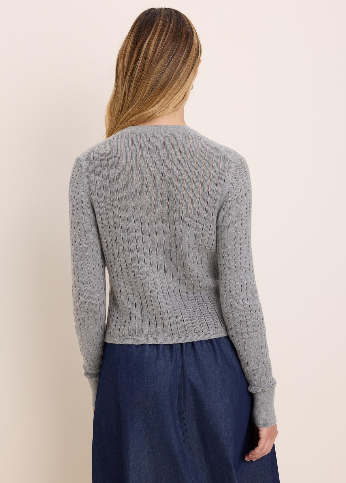 Grey long-sleeved pointelle cardigan with ribbed hem, shown from the back.