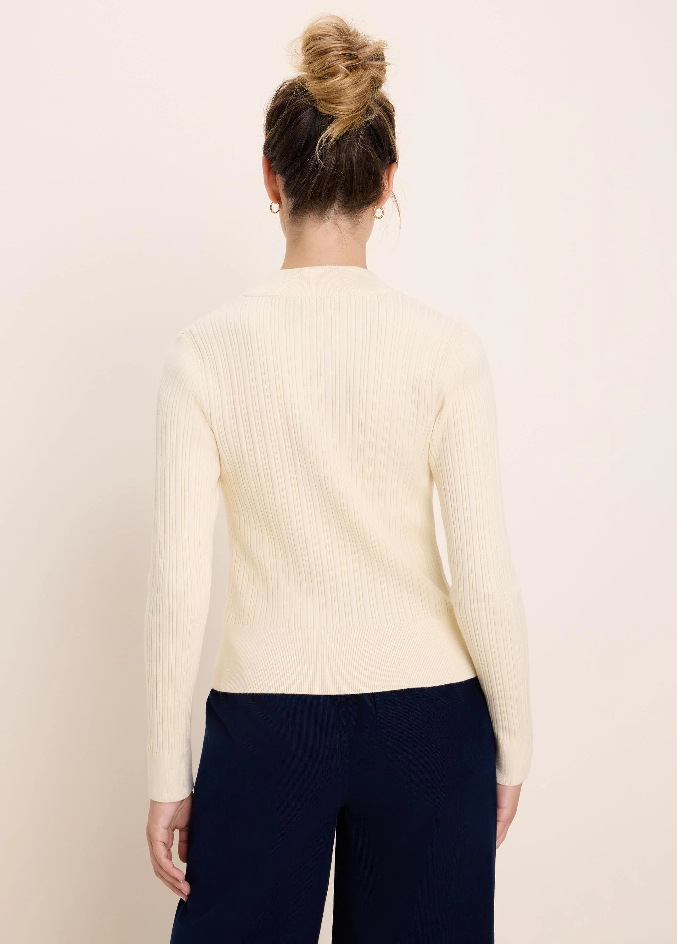Cream long-sleeve ribbed sweater, back view on model.