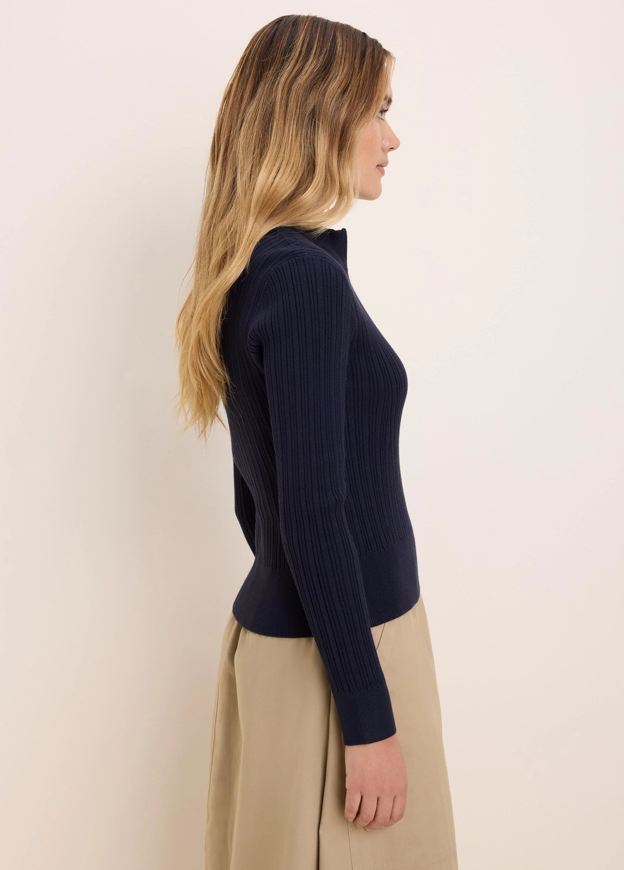 Navy blue ribbed half-zip sweater worn by model.